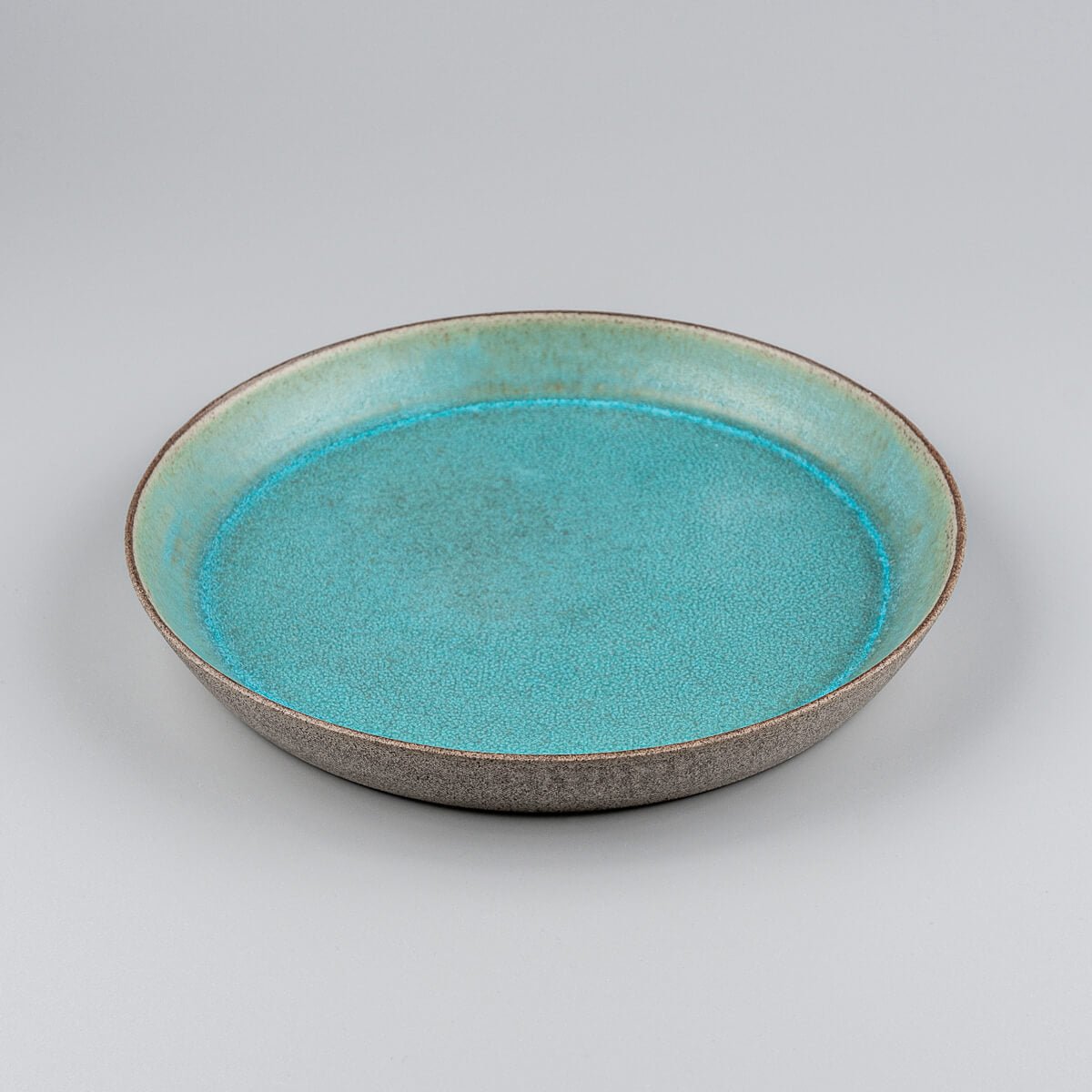 Top-down view showcasing matte turquoise finish of artisanal ceramic plate.
