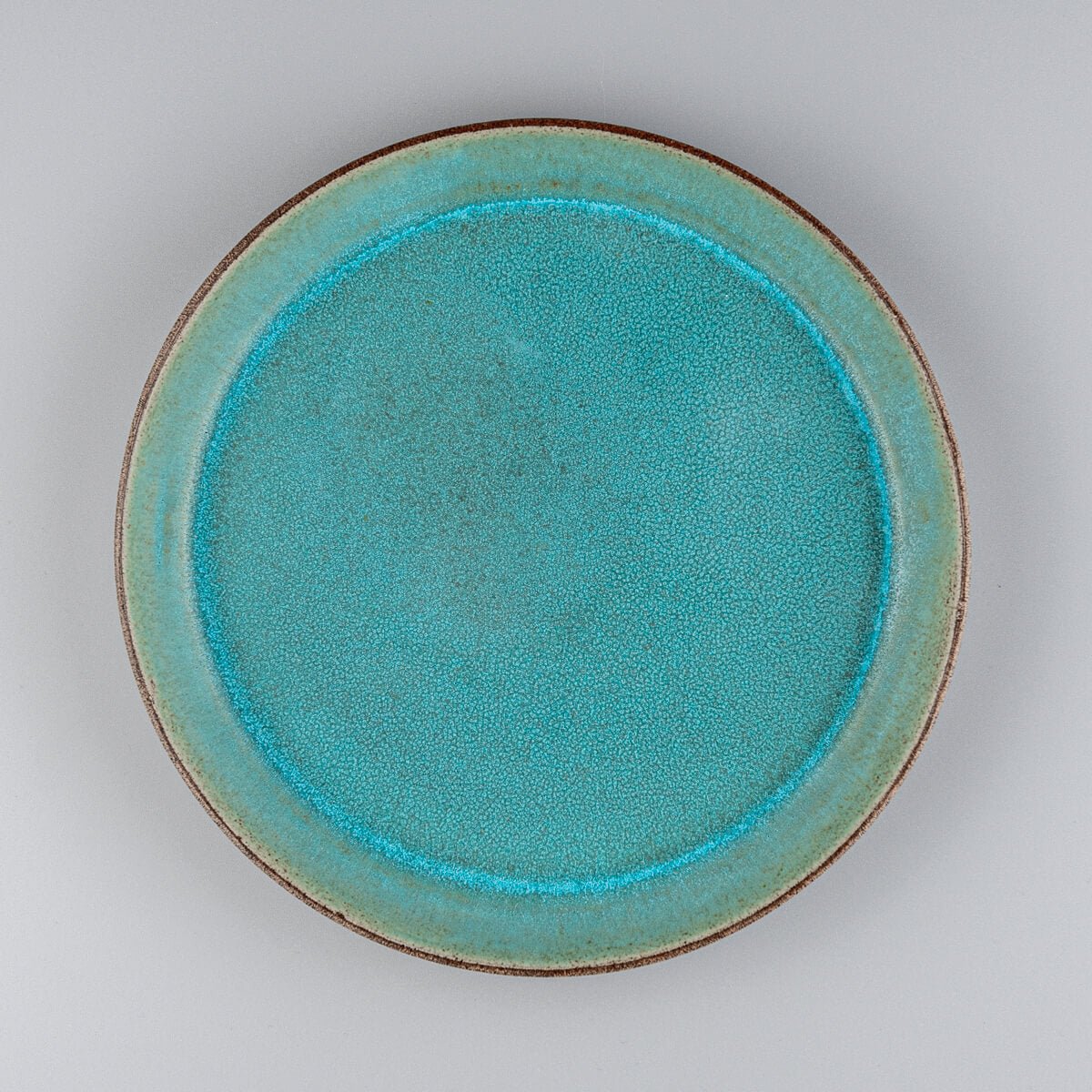 Custom ceramic plate with turquoise matte glaze for fine dining and boutique restaurant settings.