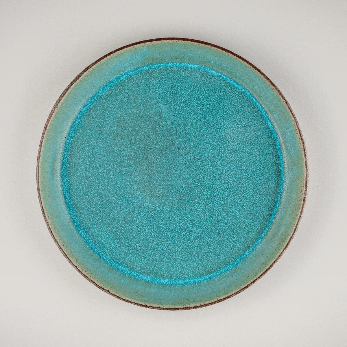 Custom ceramic plate with turquoise matte glaze for fine dining and boutique restaurant settings.