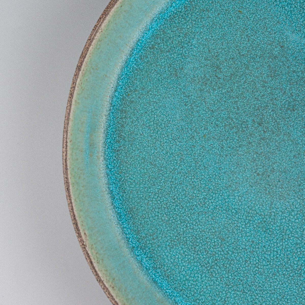 Close-up of textured turquoise interior glaze for collectible ceramic tableware.