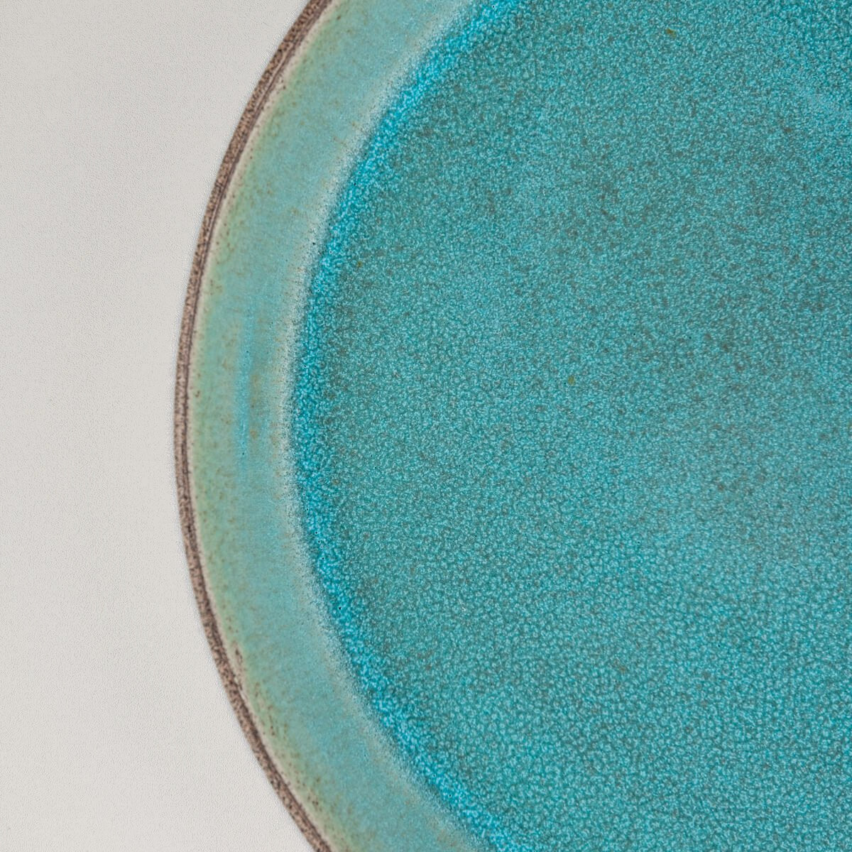Close-up of textured turquoise interior glaze for collectible ceramic tableware.