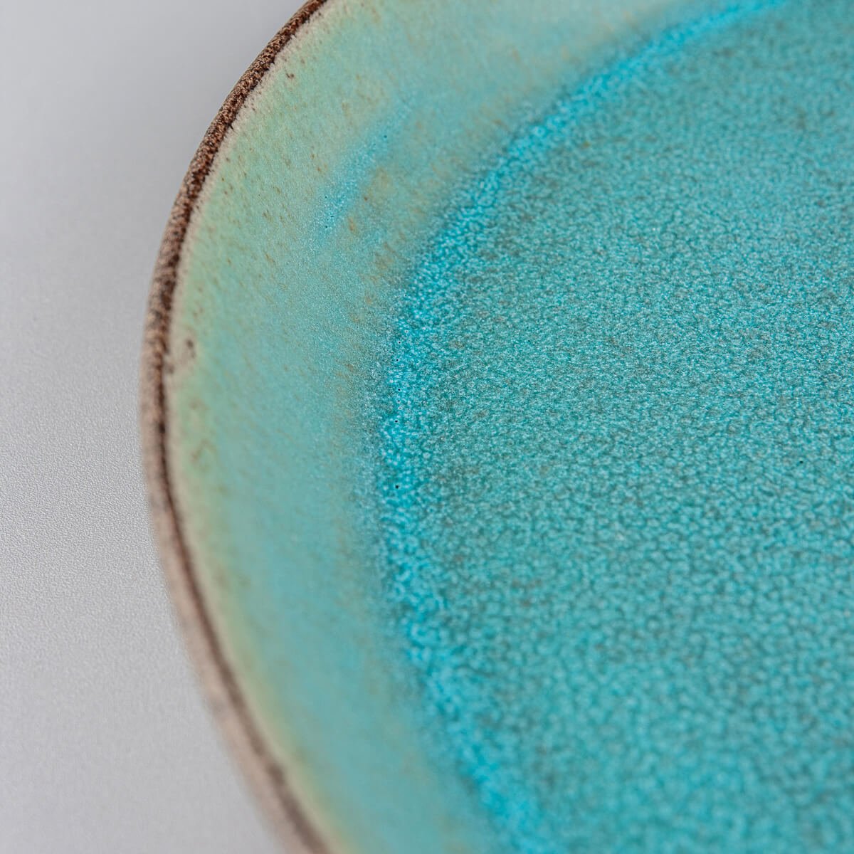 Premium ceramic plate with unique contrast between glazed interior and raw clay exterior.