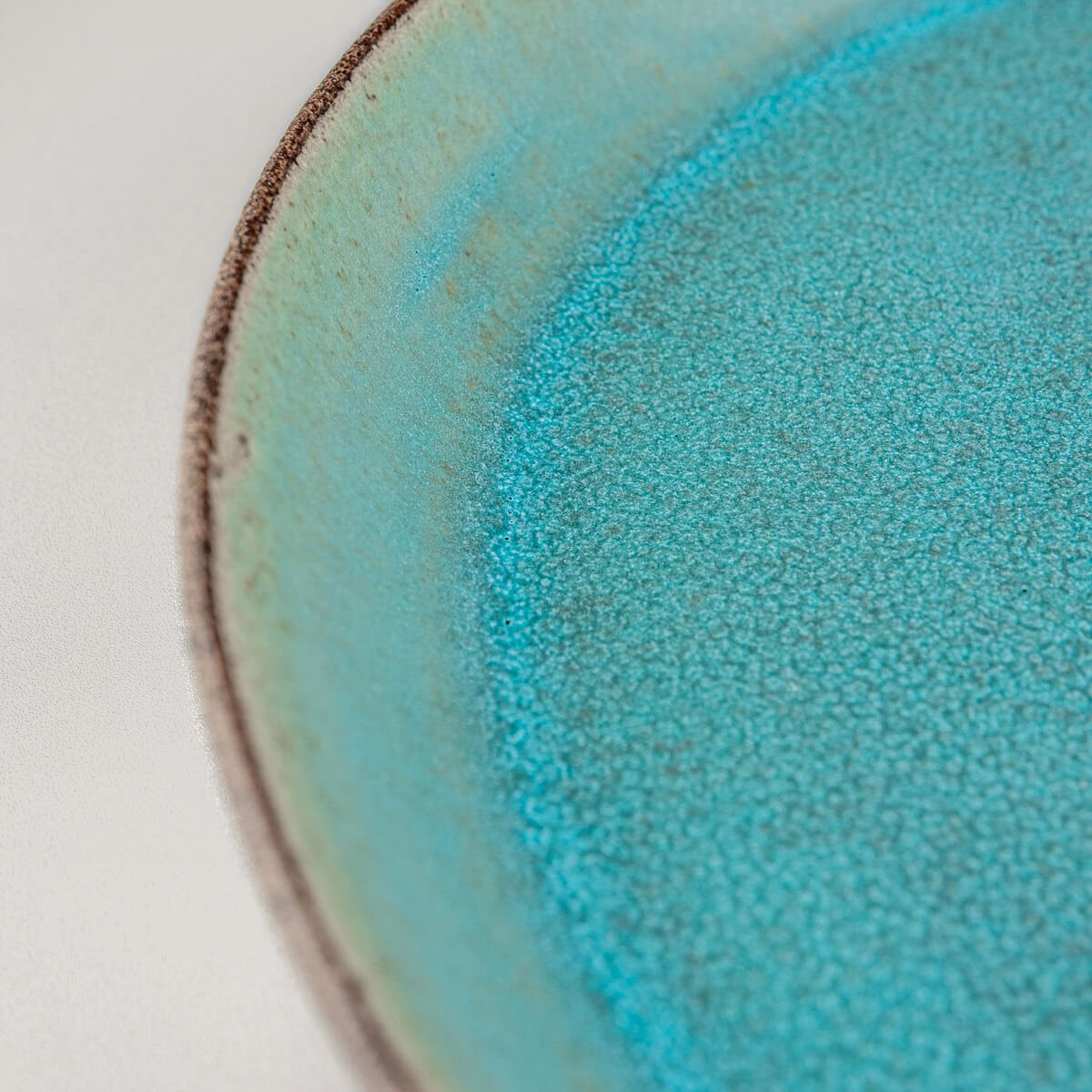 Premium ceramic plate with unique contrast between glazed interior and raw clay exterior.