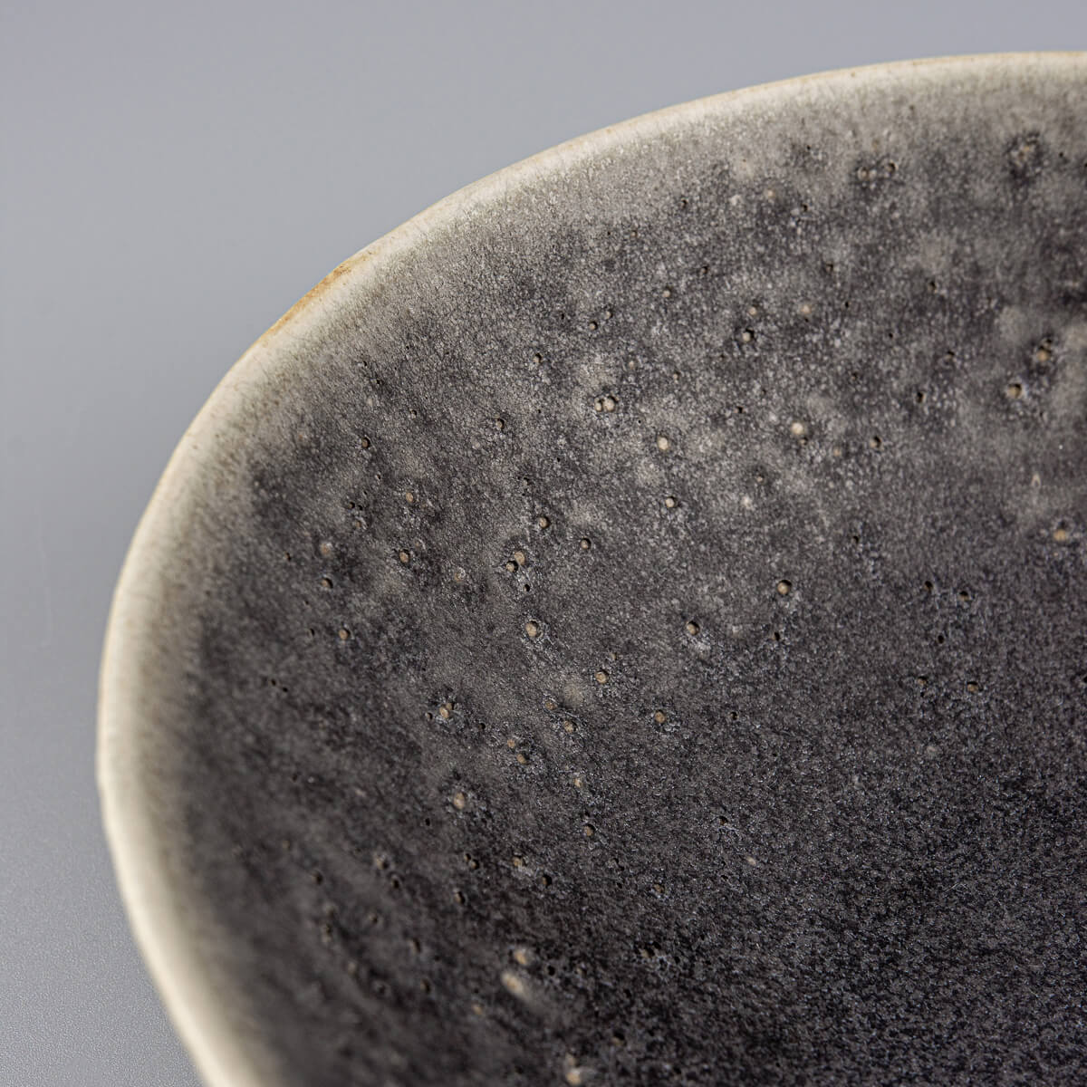 Close-up of carved rim on custom handmade ceramic bowl with natural handcrafted detail.