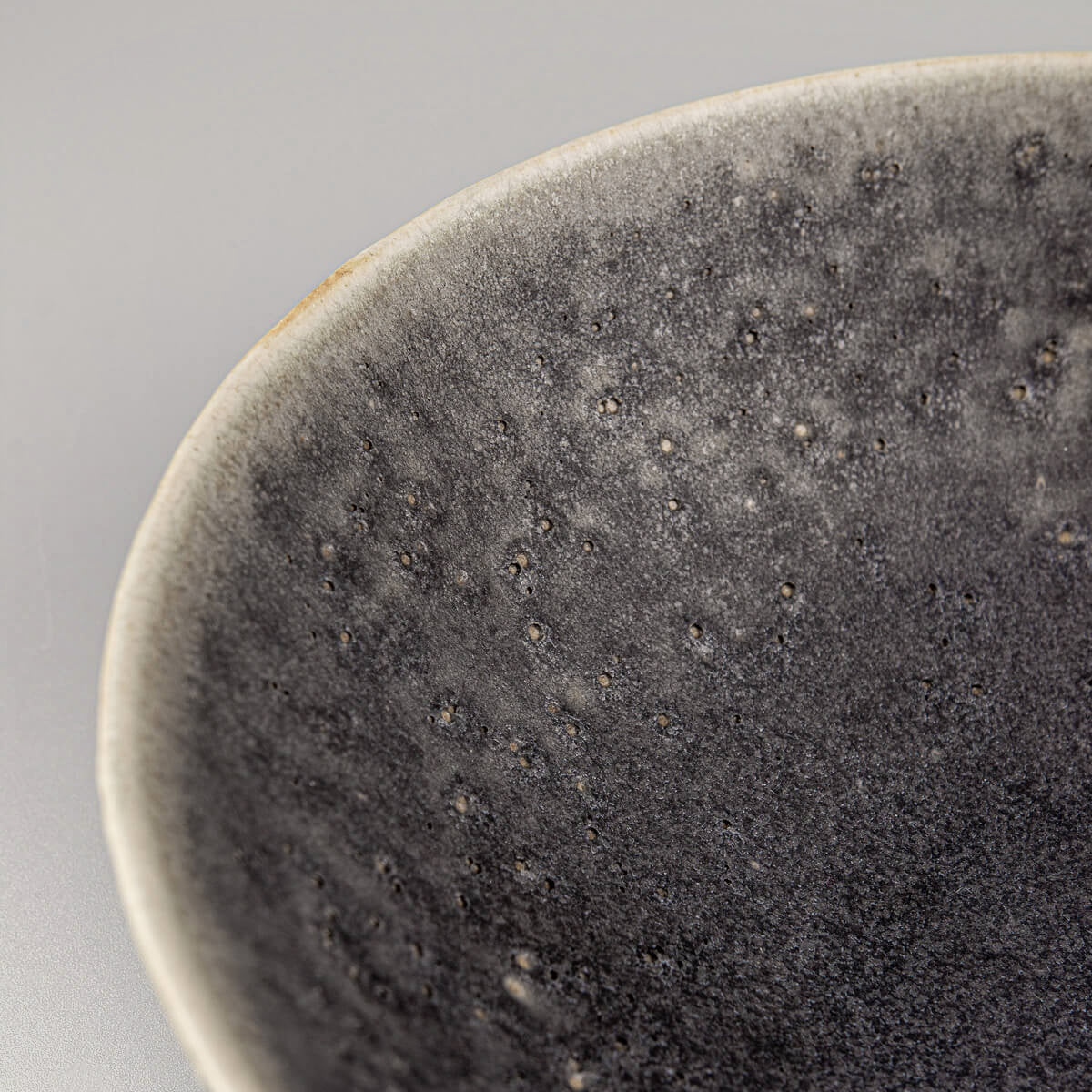 Close-up of carved rim on custom handmade ceramic bowl with natural handcrafted detail.