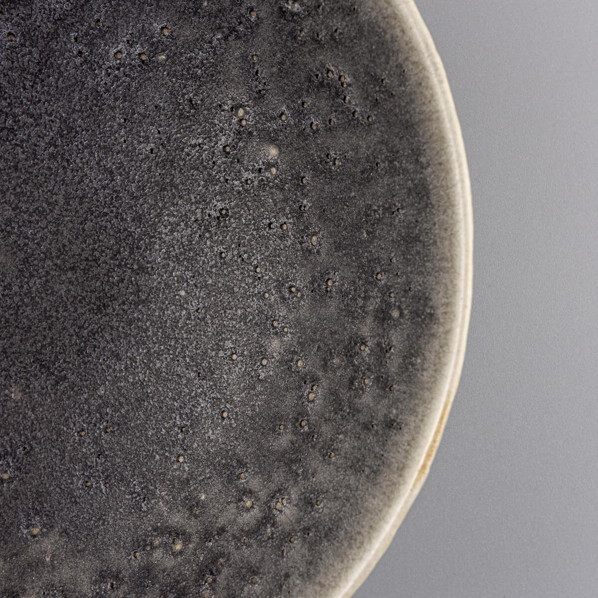 Tactile outer texture of artisan ceramic bowl with sculpted surface and depth.