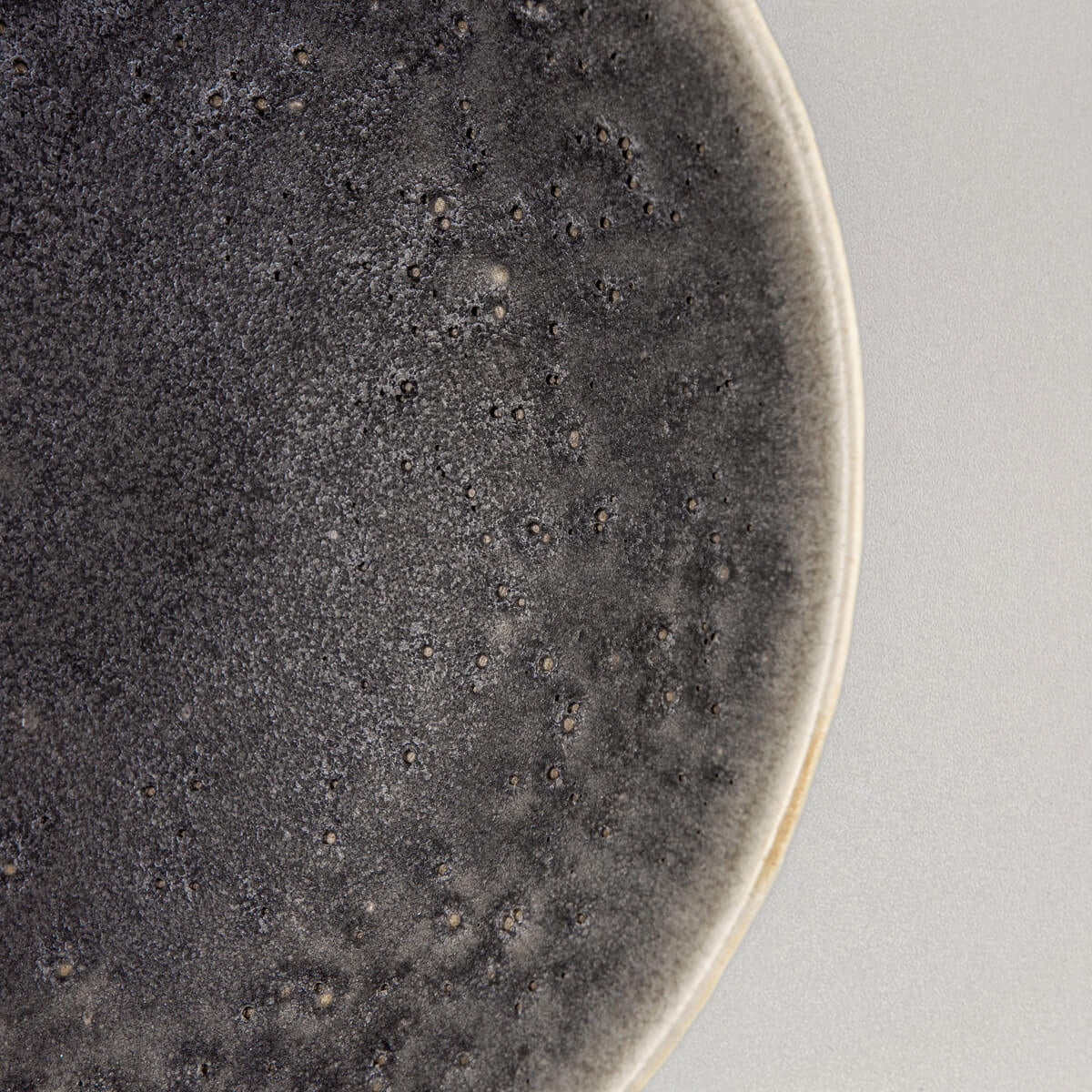 Tactile outer texture of artisan ceramic bowl with sculpted surface and depth.
