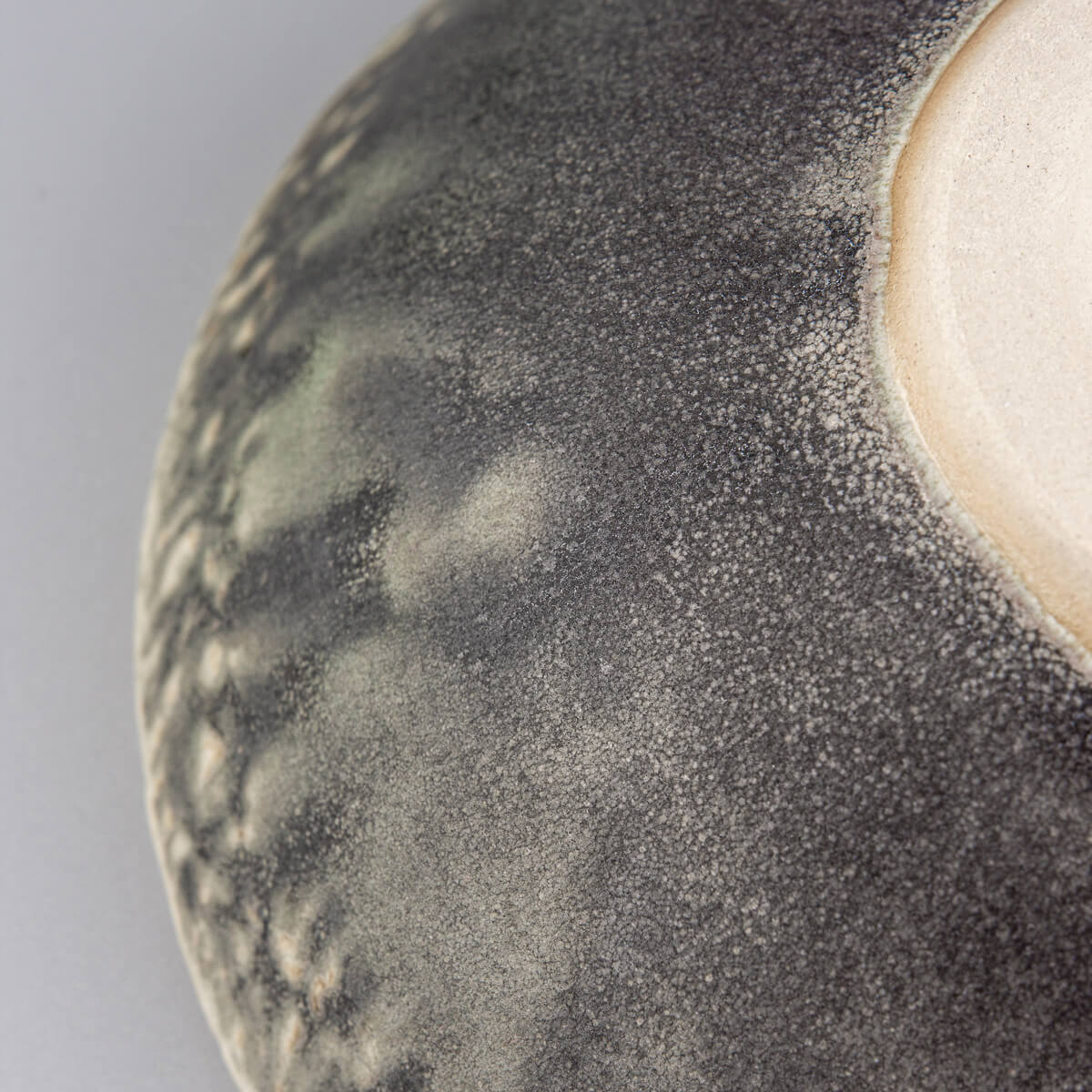 Bottom view of ceramic bowl displaying foot ring and raw stoneware finish.