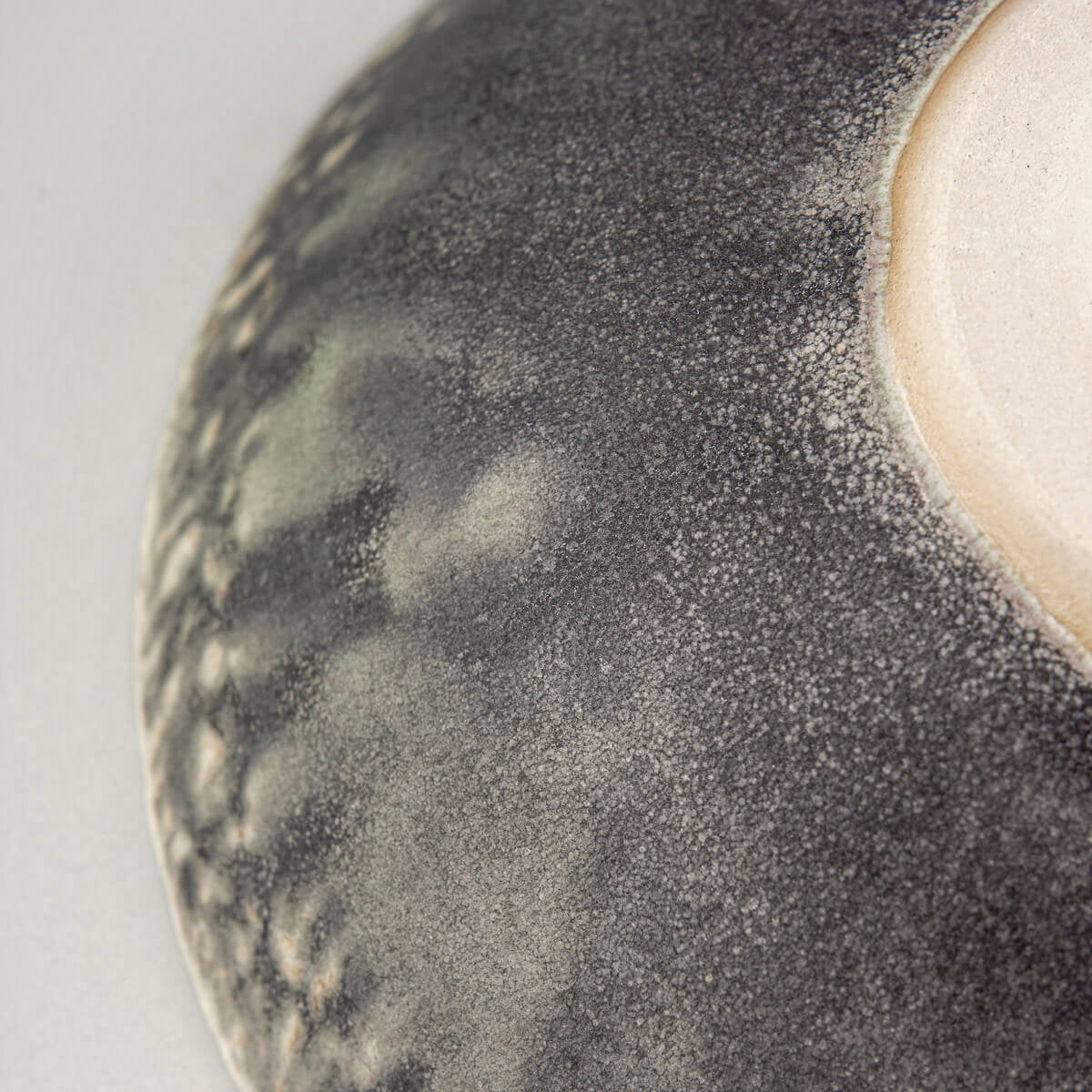 Bottom view of ceramic bowl displaying foot ring and raw stoneware finish.
