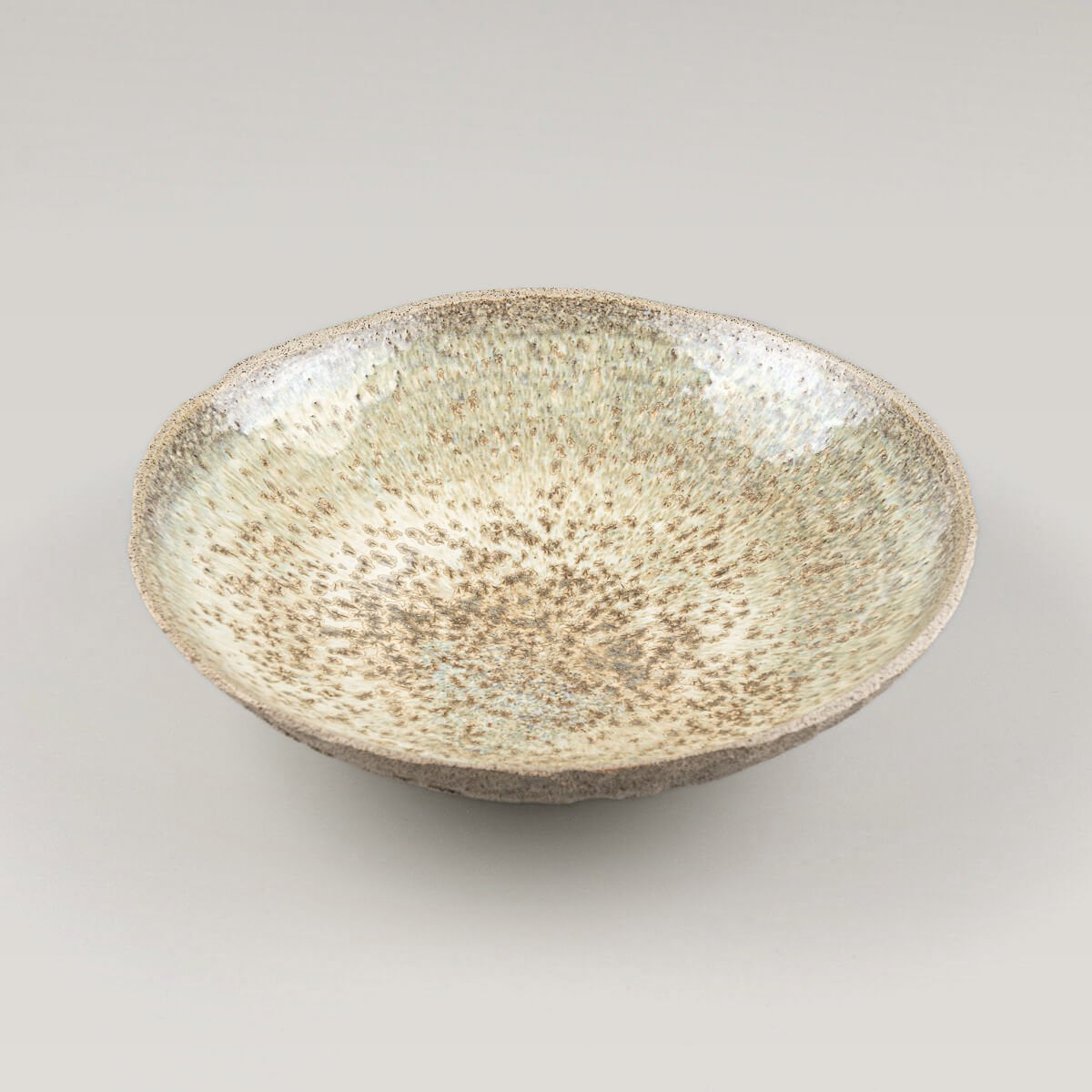 Hand-holding view of custom handmade ceramic plate, highlighting scale and fine craftsmanship.