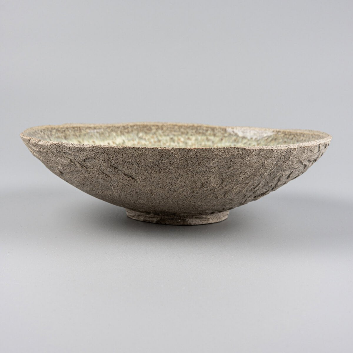 Top view of designer ceramic plate with glossy, speckled glaze ideal for boutique restaurant use.
