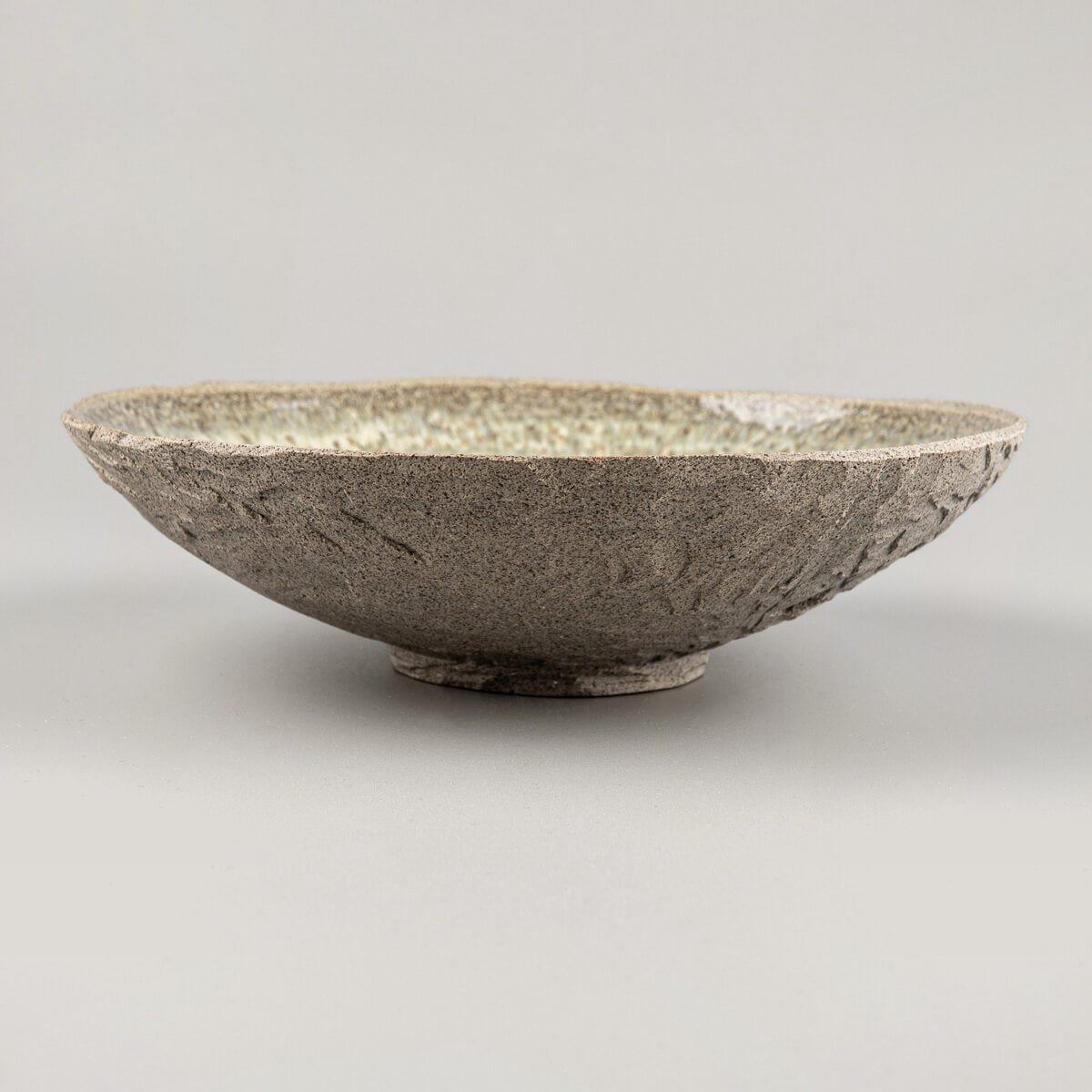 Top view of designer ceramic plate with glossy, speckled glaze ideal for boutique restaurant use.