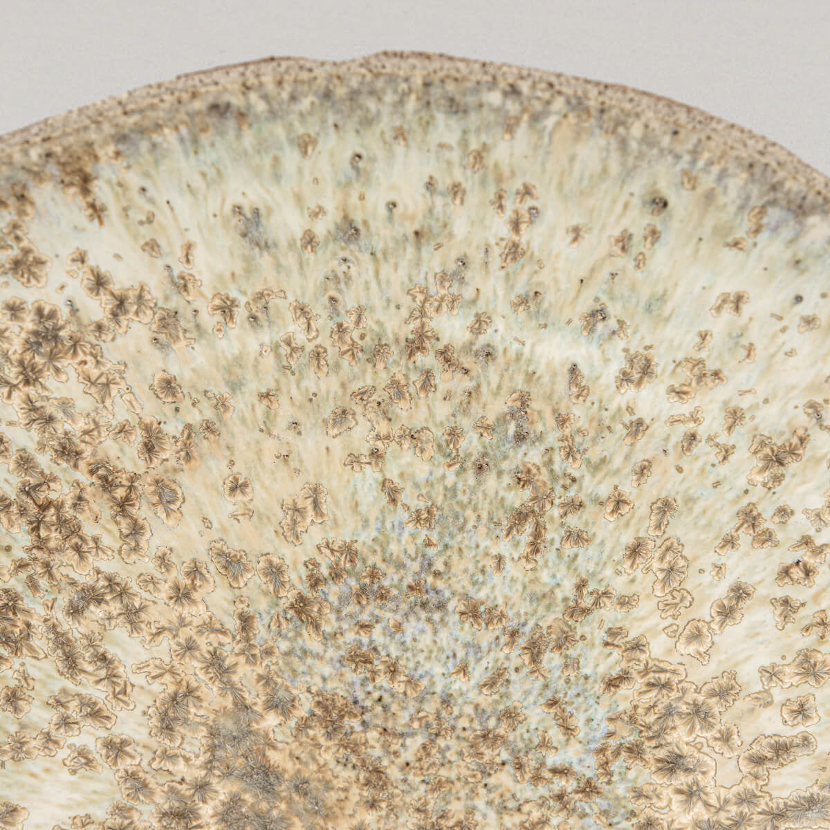 Angled image showing deep bowl form and hand-carved exterior of fine ceramic plate.