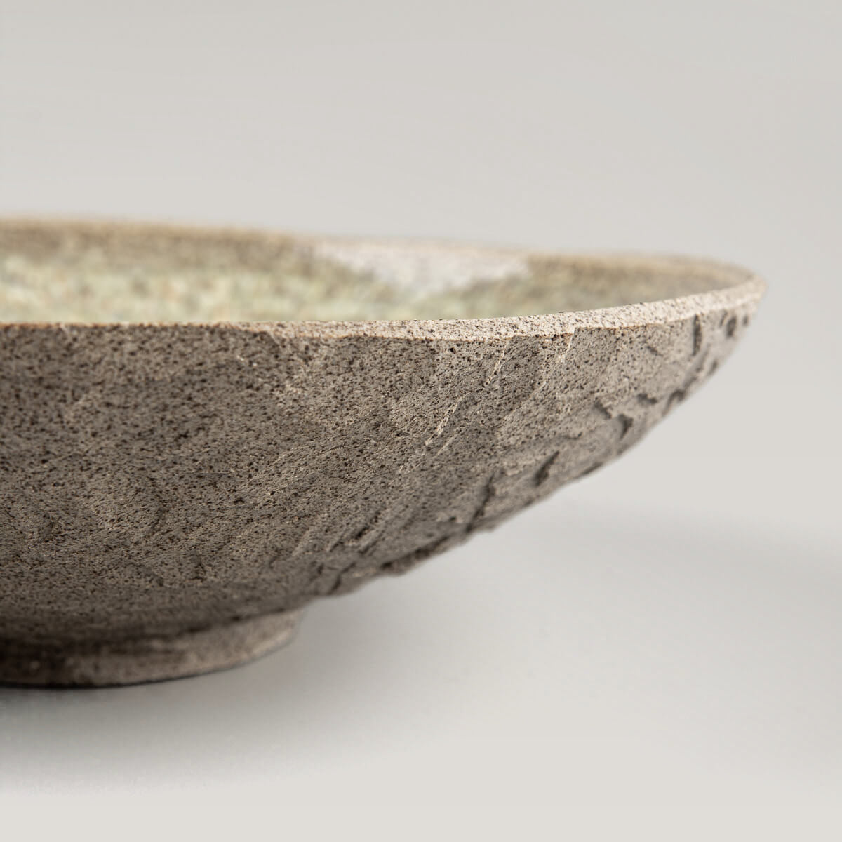 Detailed view of inner glaze pattern on handmade ceramic stoneware dinner plate.