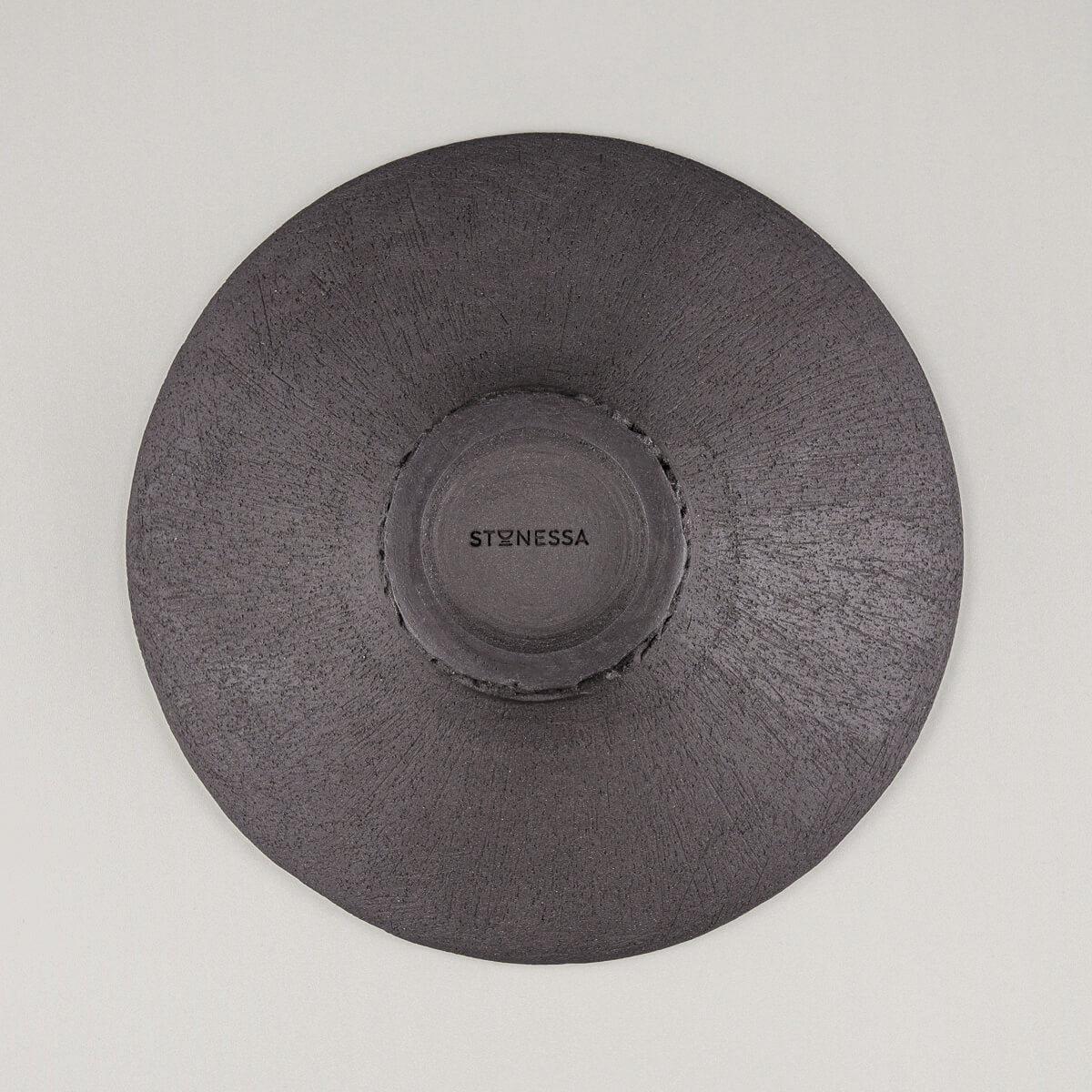 Underside of handmade ceramic plate featuring textured black stoneware.