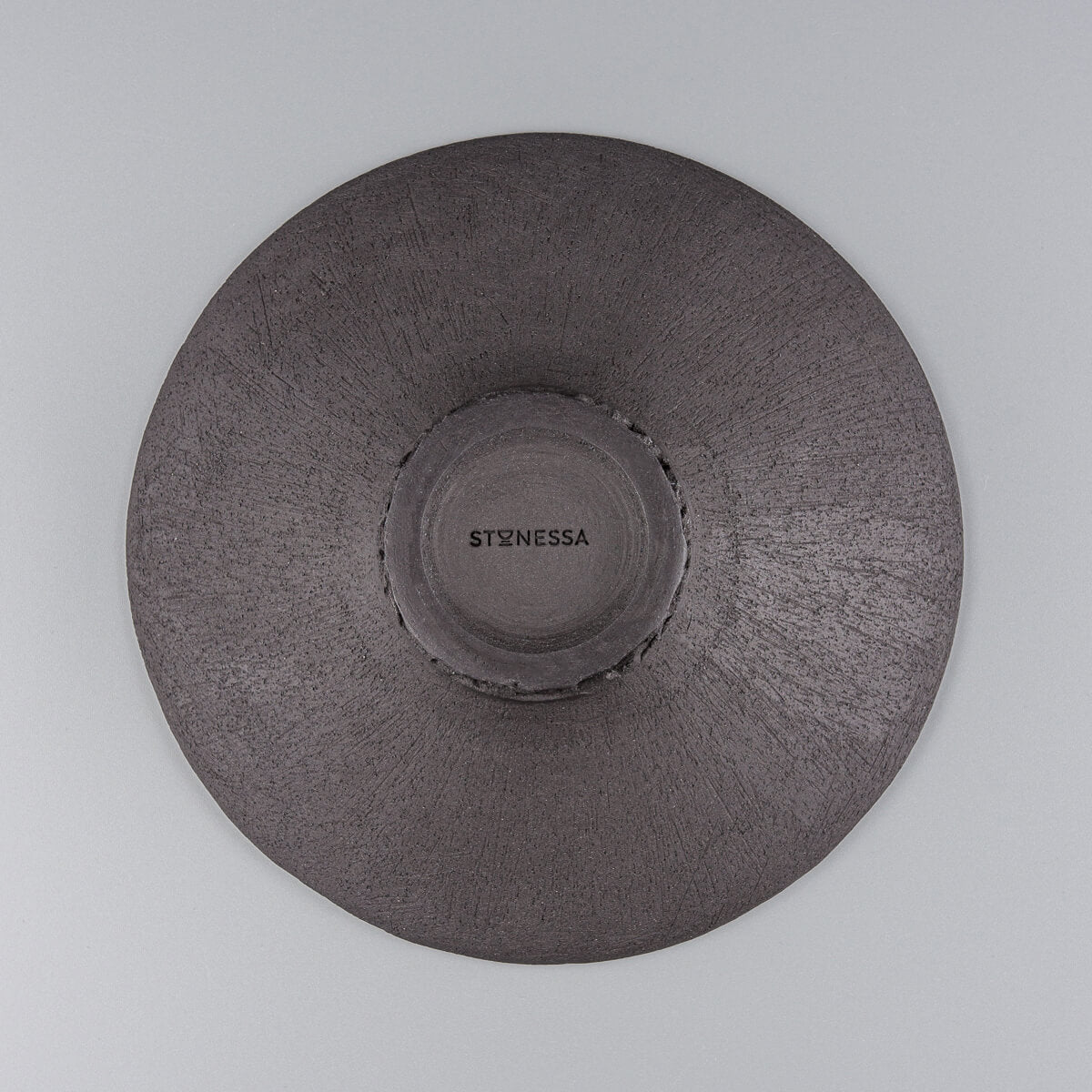 Unglazed plate base revealing natural black clay texture for artisanal authenticity.