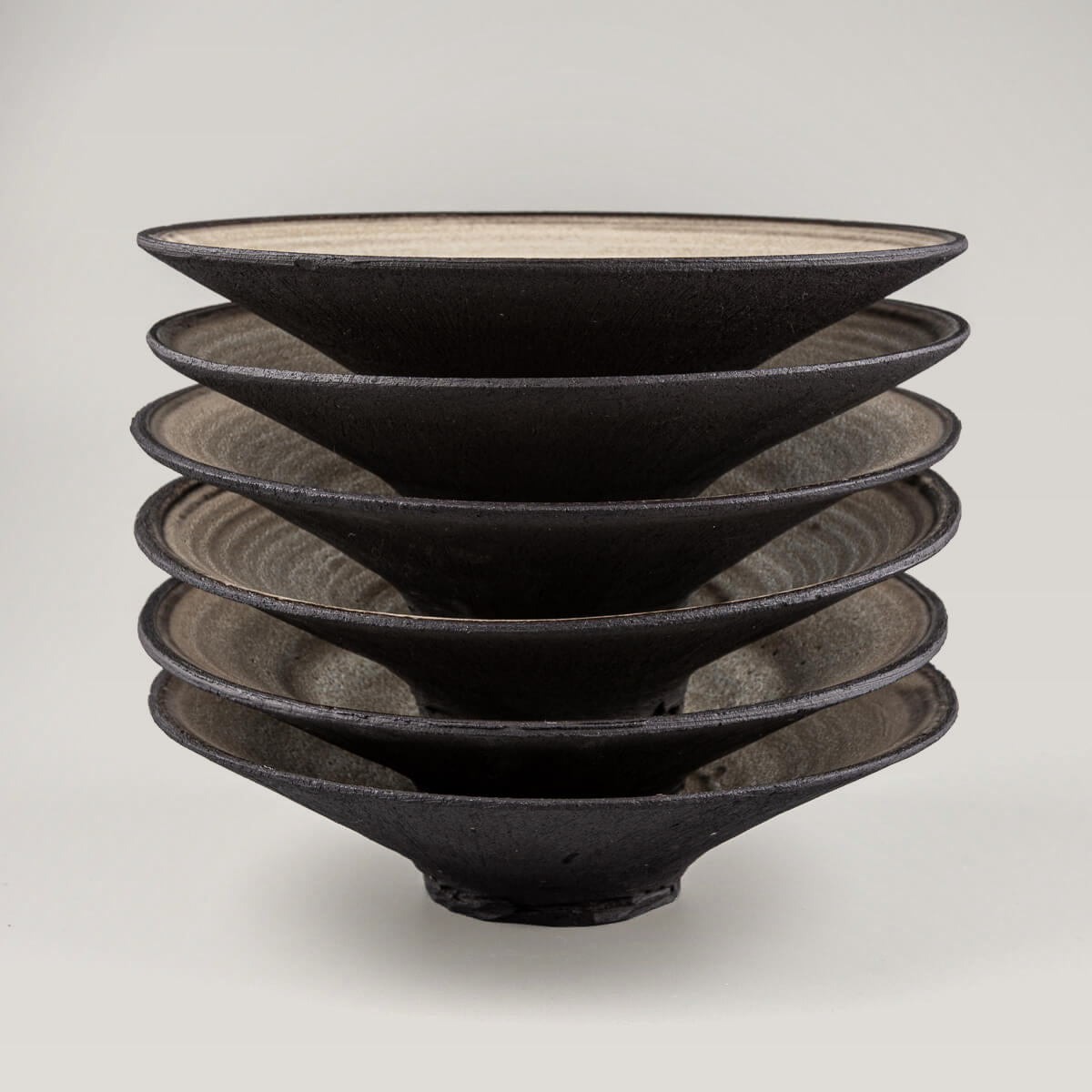 Stack of handmade ceramic plates combining functional form and visual harmony.