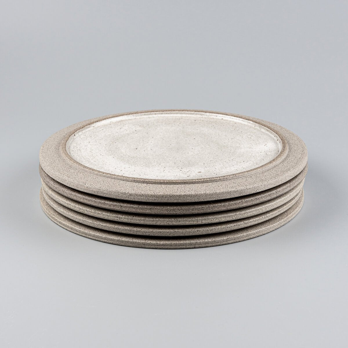 Stacked handmade stoneware plates for boutique restaurants and curated kitchenware.