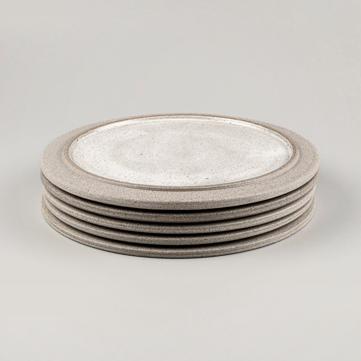 Stacked handmade stoneware plates for boutique restaurants and curated kitchenware.