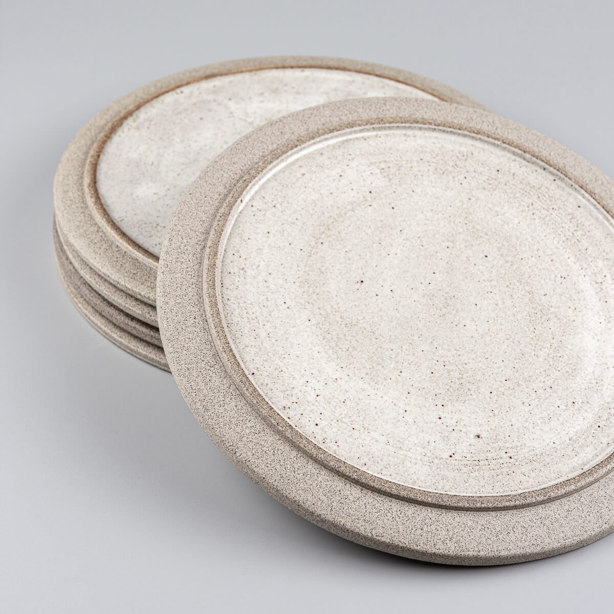 Set of modern ceramic plates made from dark clay, glazed for elegance and durability.