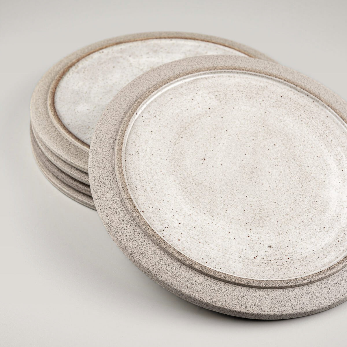 Set of modern ceramic plates made from dark clay, glazed for elegance and durability.