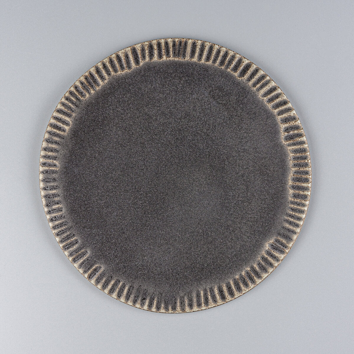 Handmade ceramic serving plate in dark matte glaze for desserts and fine dining.