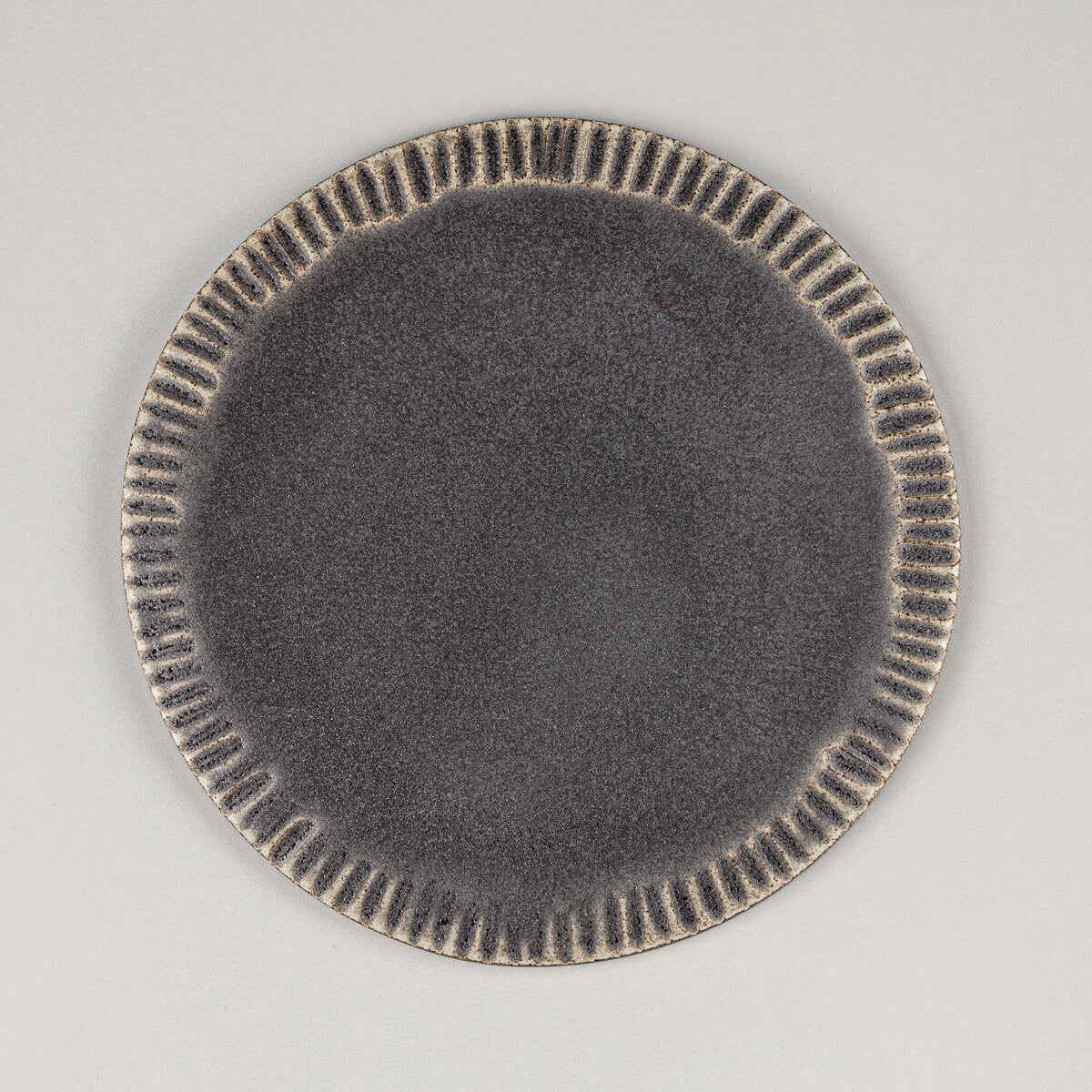 Handmade ceramic serving plate in dark matte glaze for desserts and fine dining.
