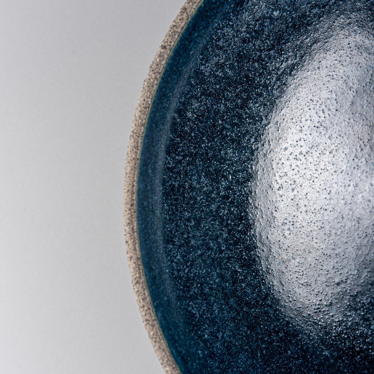 Detail of rim showing transition between raw exterior and glazed ceramic interior.
