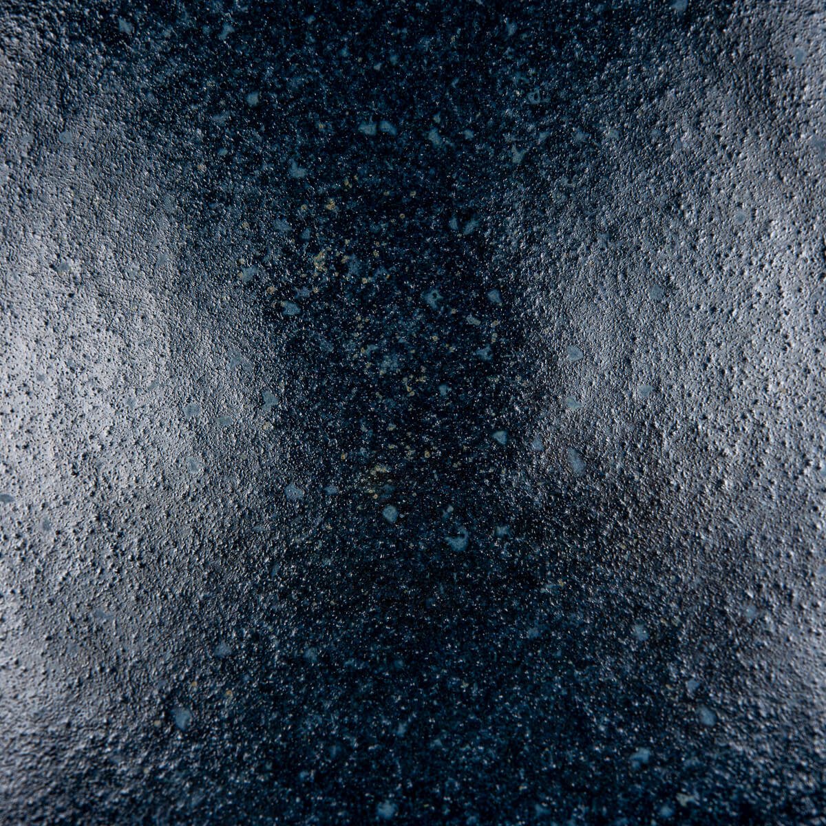 Macro shot of matte blue glaze inside artisan pottery bowl for fine dining.