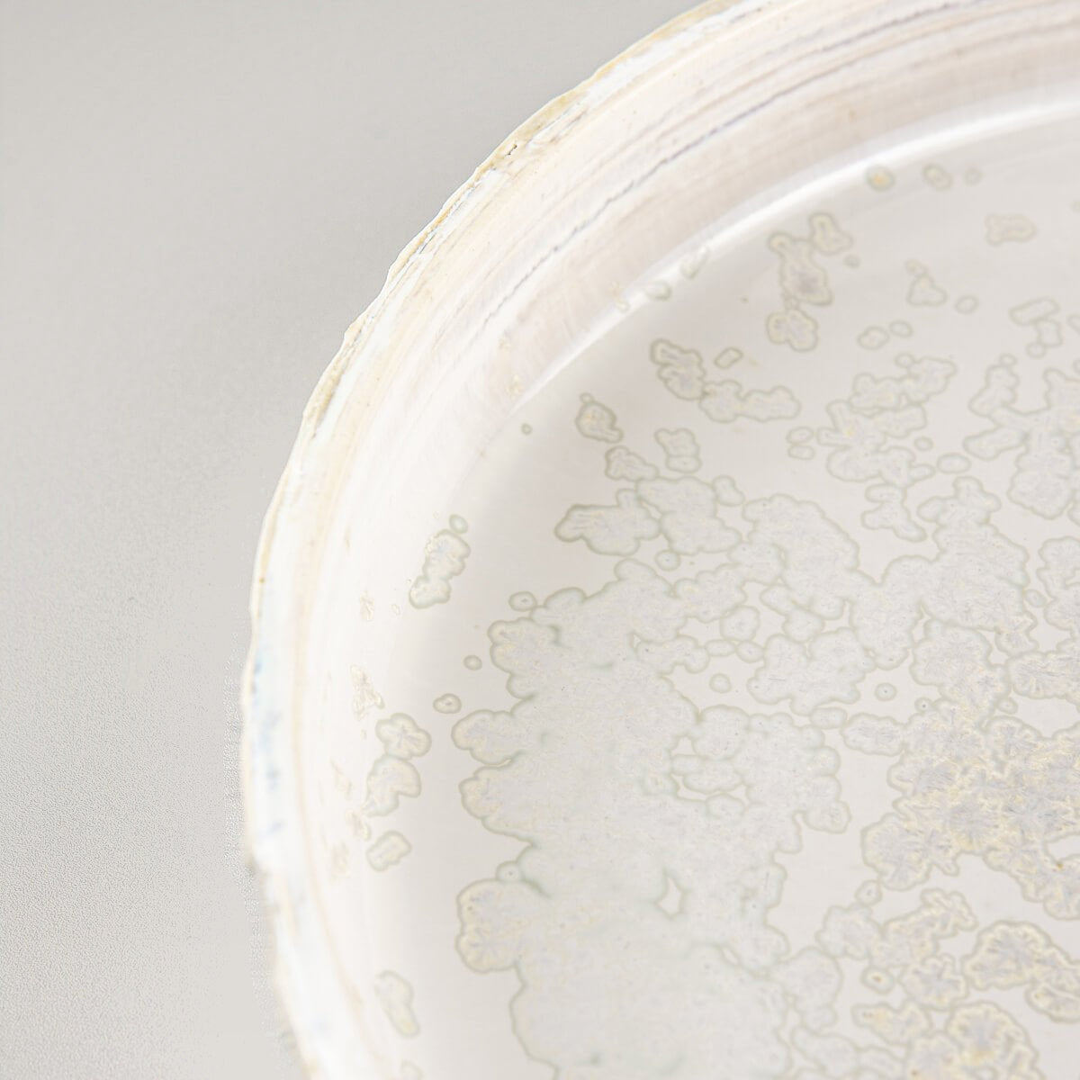 Interior view of artisan plate showing complementary soft gray glaze for luxury table settings.