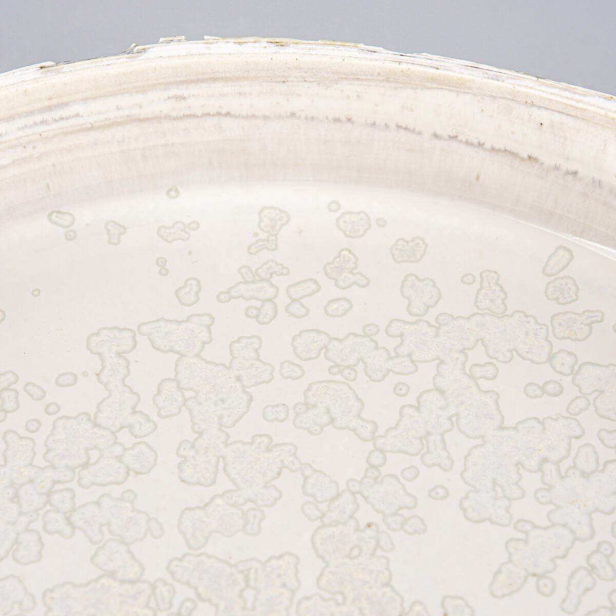 Close-up of plate’s rim with subtle chipping for organic artisan finish.