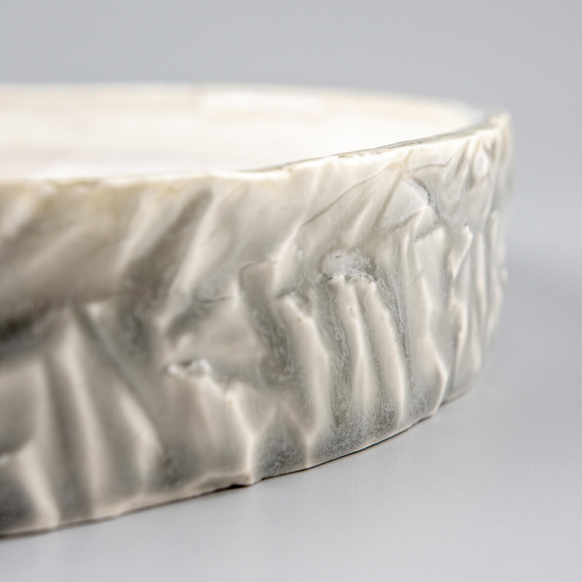 Close-up of plate’s rim with subtle chipping for organic artisan finish.