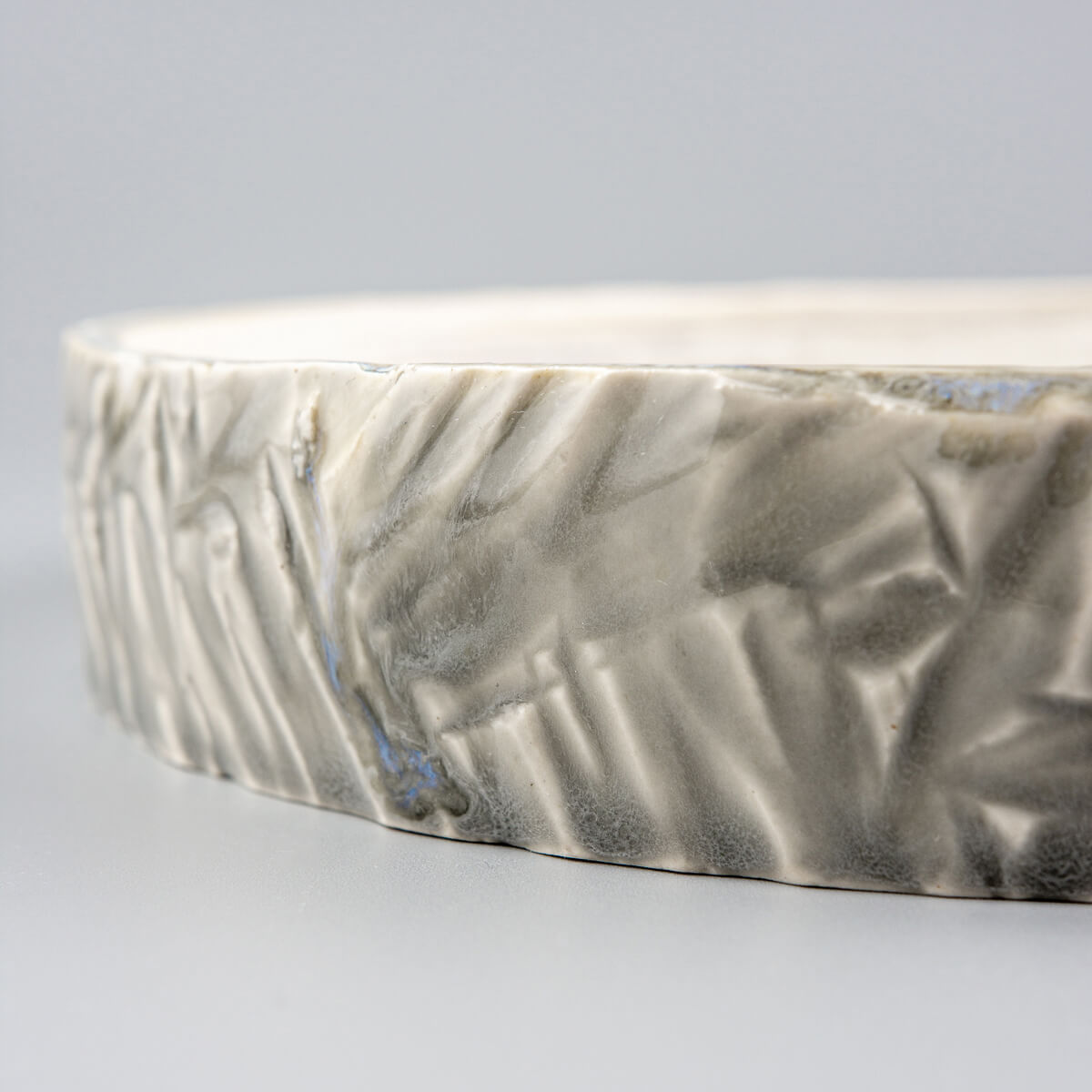 Premium ceramic plate for fine dining with carved details and a glossy finish.