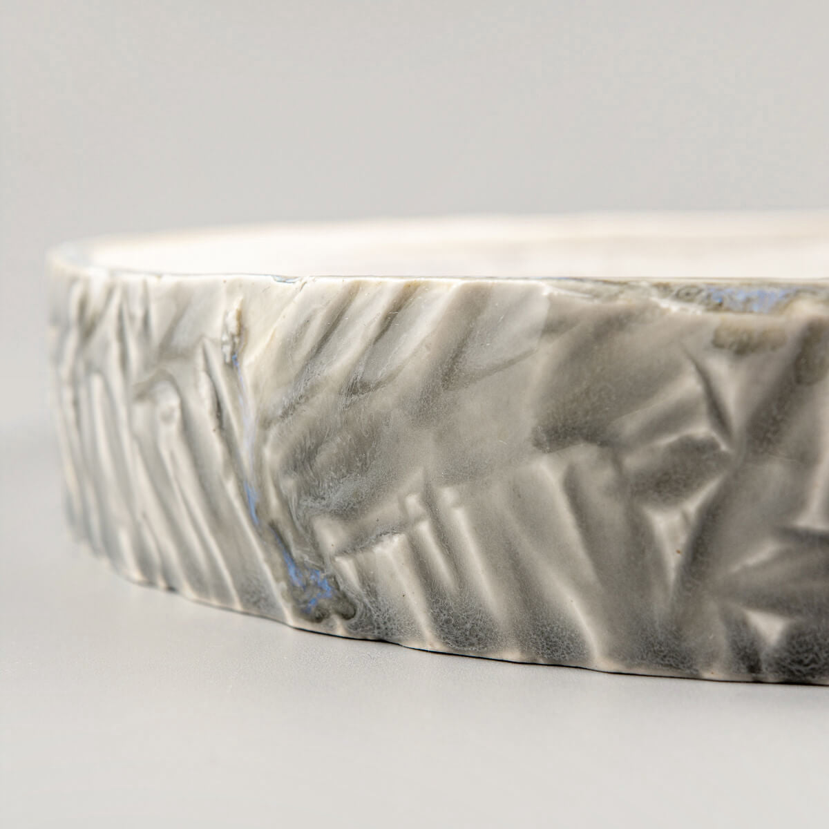 Premium ceramic plate for fine dining with carved details and a glossy finish.