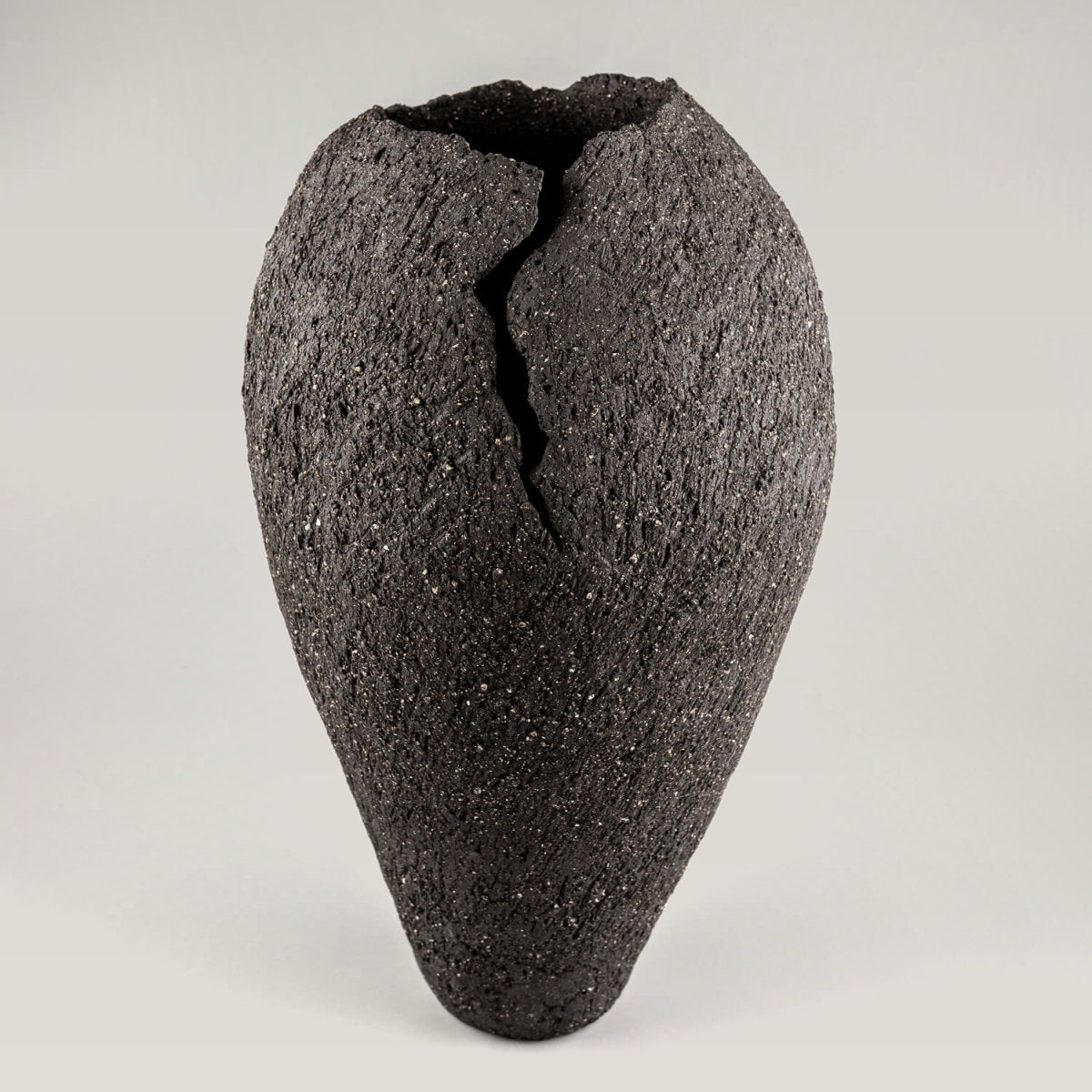 Handmade ceramic vases with dark stoneware clay and sculptural crack design for luxury interiors.