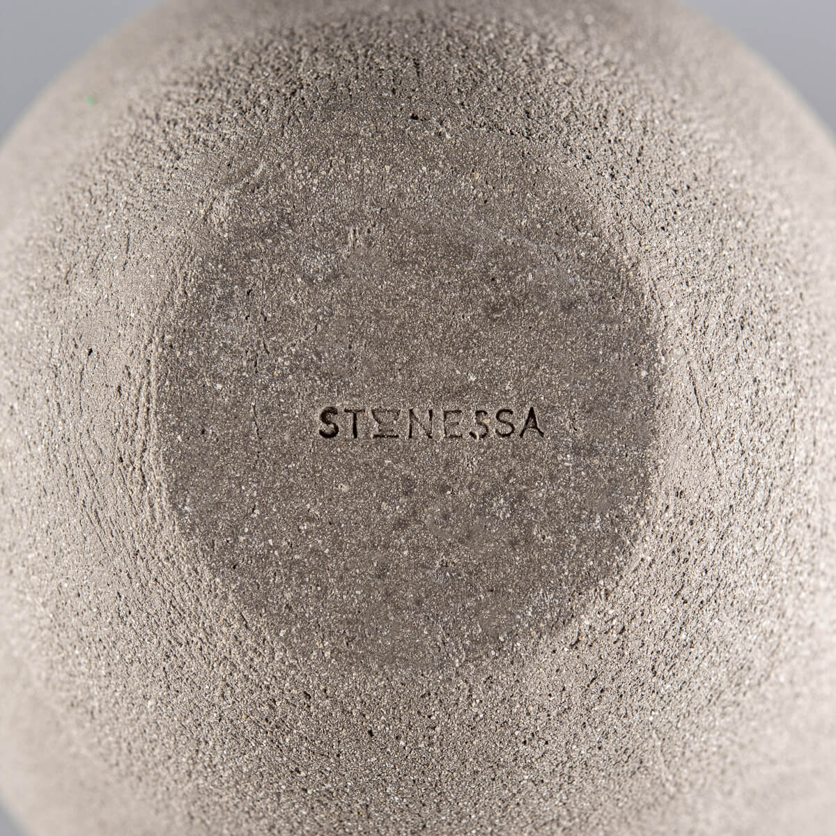 Close-up of a handmade vase base with ean mbossed maker’s mark, Stonessa for collectible pottery.