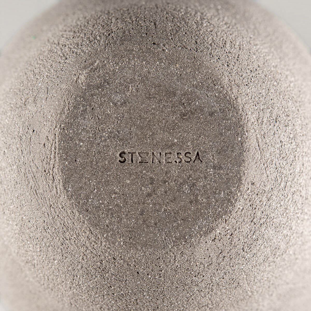 Close-up of a handmade vase base with ean mbossed maker’s mark, Stonessa for collectible pottery.