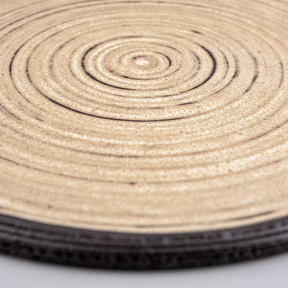 Premium ceramic plate in ocher glaze with unglazed black clay edge for gourmet serving.