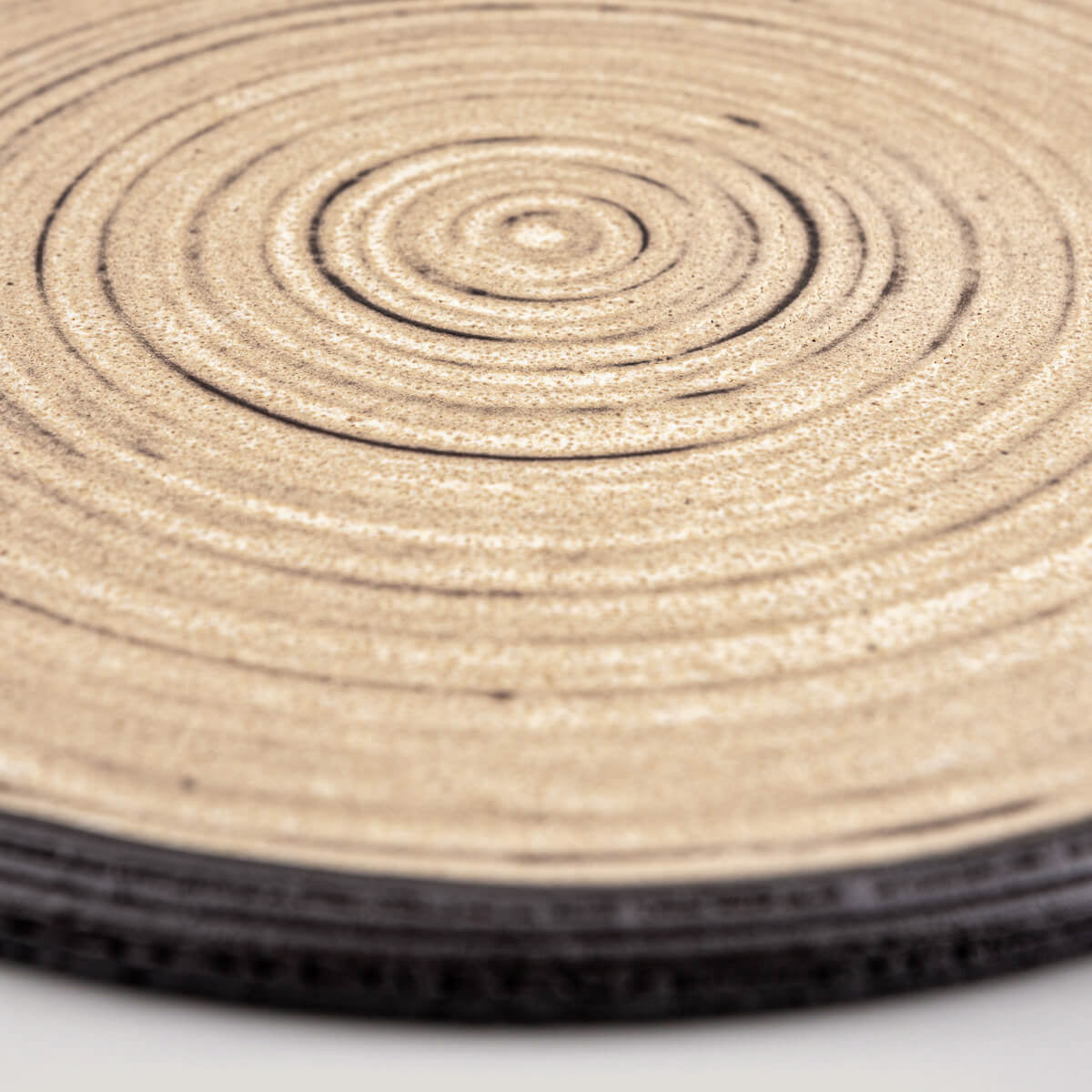 Premium ceramic plate in ocher glaze with unglazed black clay edge for gourmet serving.
