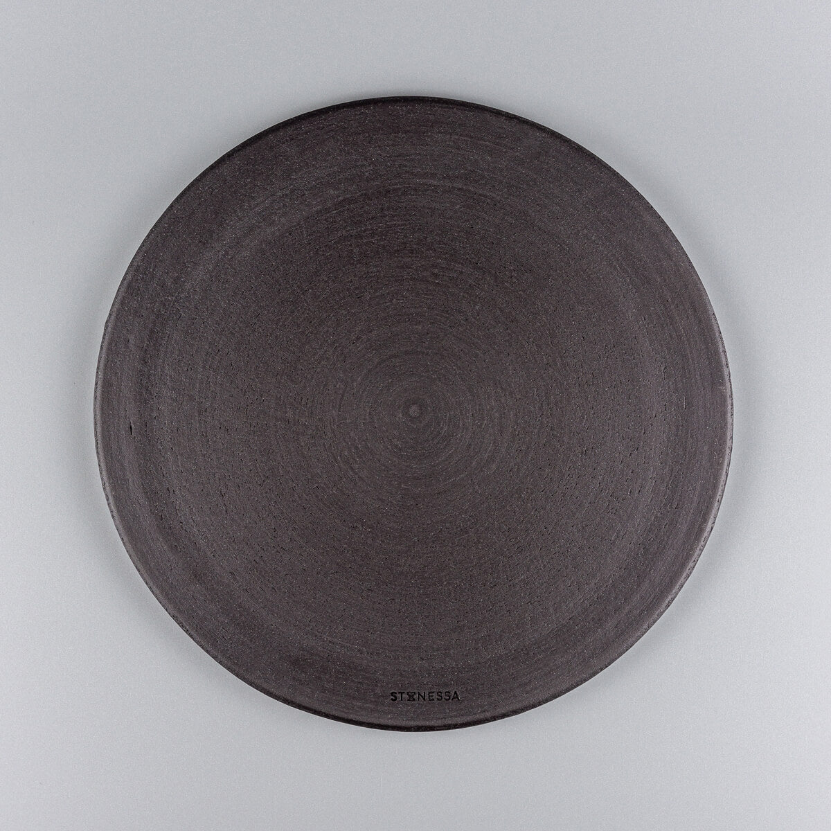 Bottom view of handmade ceramic plate in unglazed black stoneware.