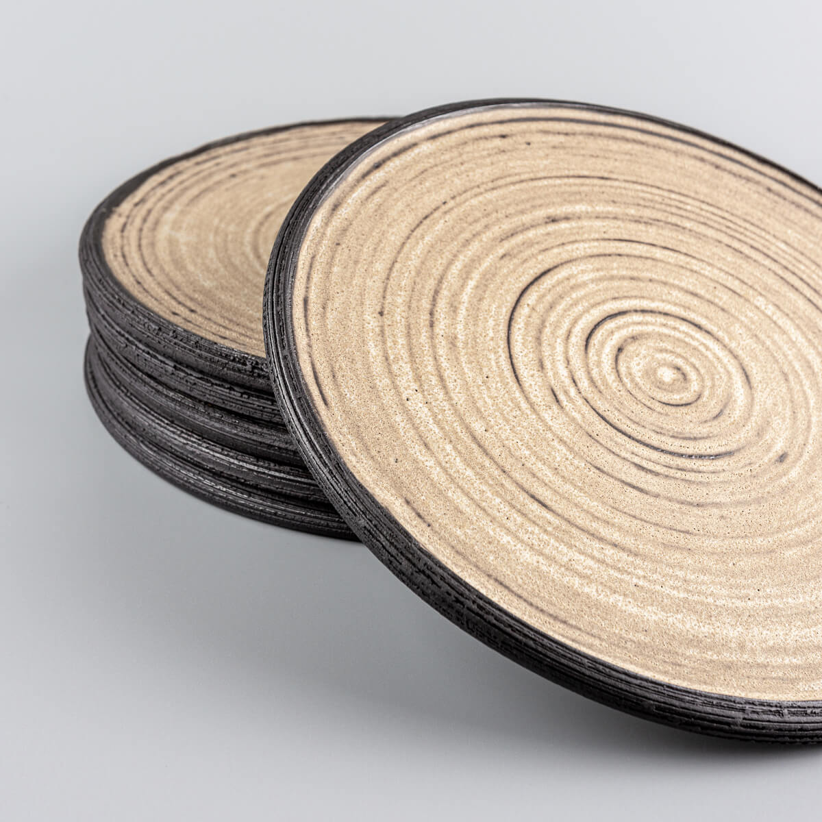 Artisan ceramic plates with ocher glaze and black clay edge for restaurant plating.