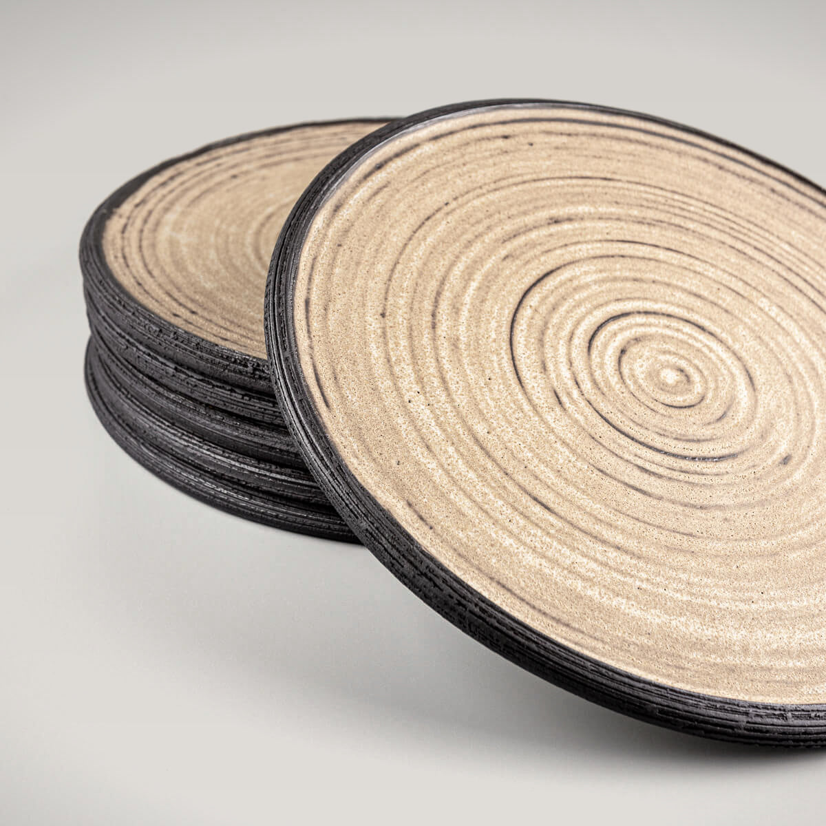 Artisan ceramic plates with ocher glaze and black clay edge for restaurant plating.