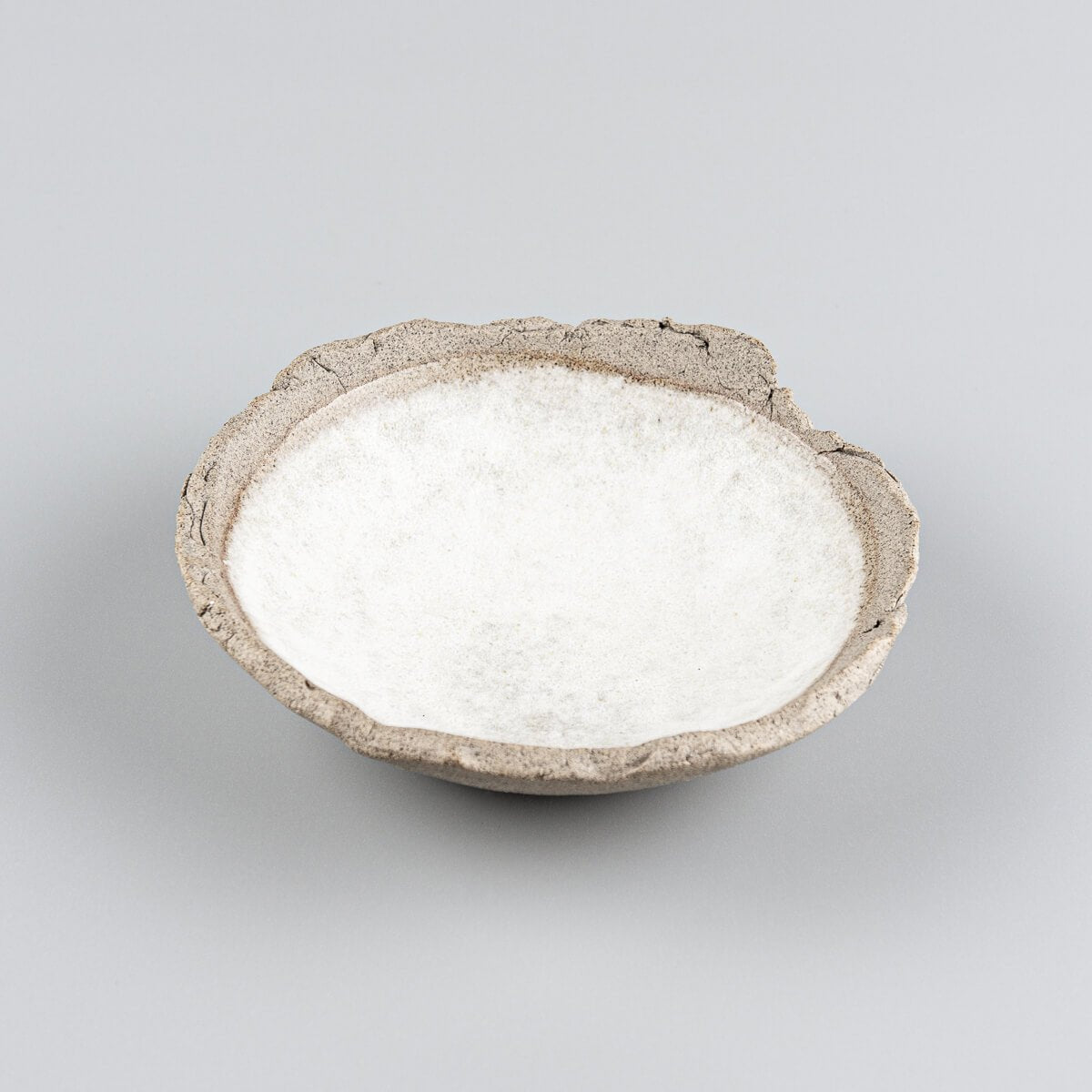 Handcrafted stoneware sushi plate with white matte glazed interior and natural textured clay rim.