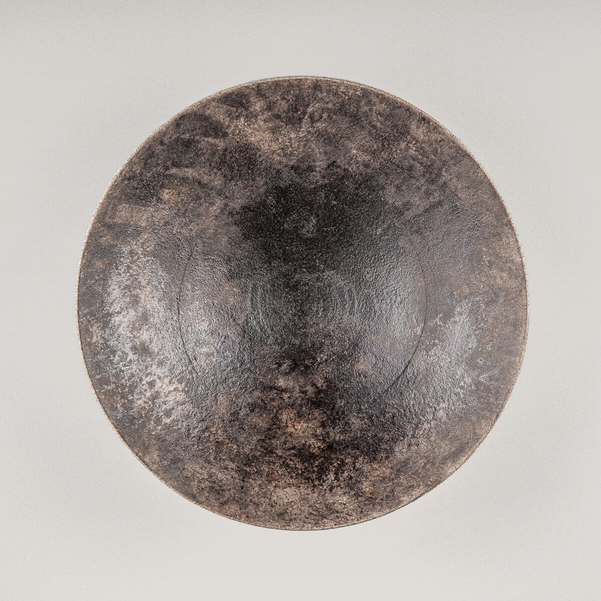 Elegant artisan stoneware plate with hand-carved base and glazed interior for fine dining.