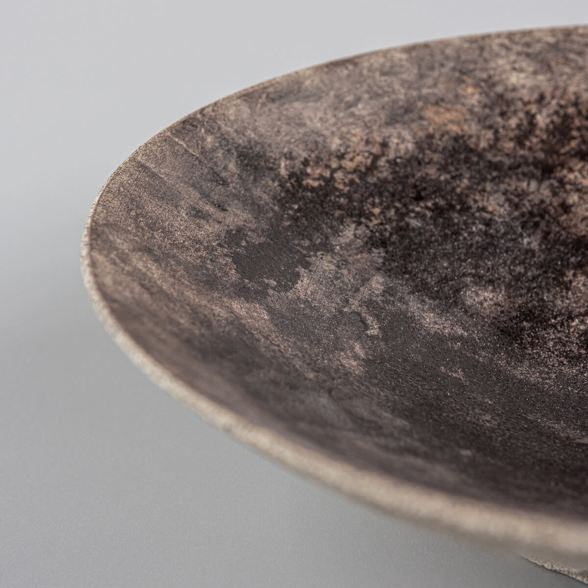 Side view of handcrafted stoneware plate with cone-shaped profile.