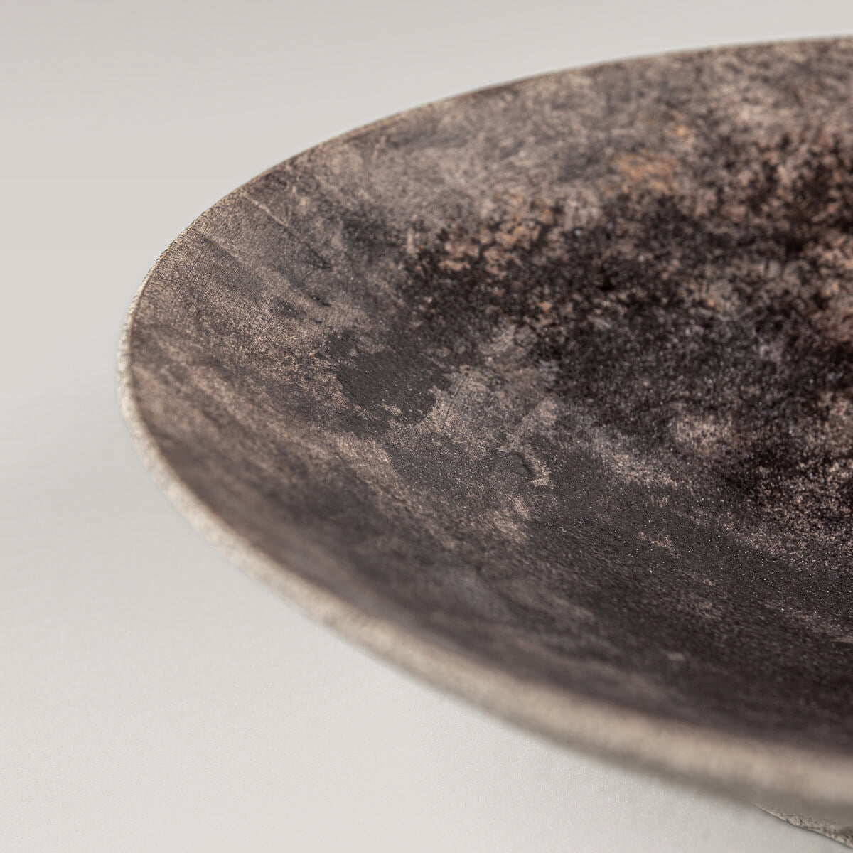 Side view of handcrafted stoneware plate with cone-shaped profile.