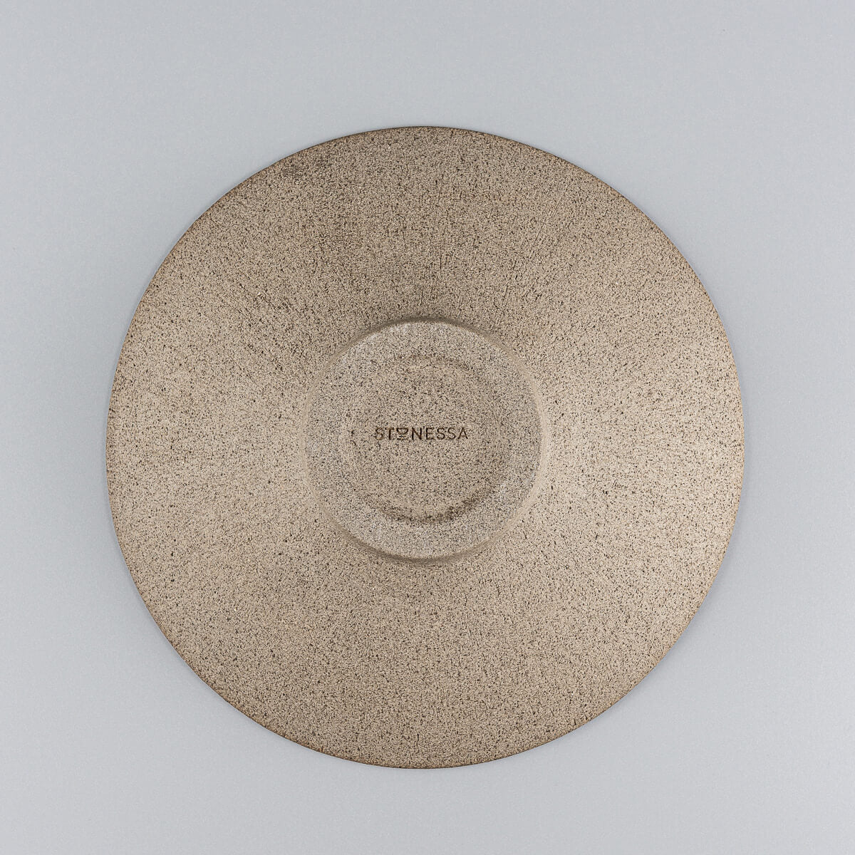 Underside view of artisanal ceramic plate showcasing raw, unglazed stoneware base.