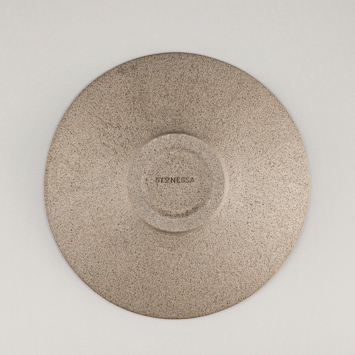 Underside view of artisanal ceramic plate showcasing raw, unglazed stoneware base.