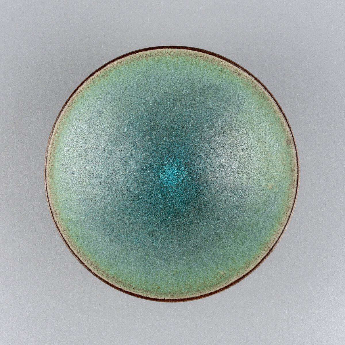 Elegant handmade ceramic plate with matte turquoise glaze for fine dining presentation.