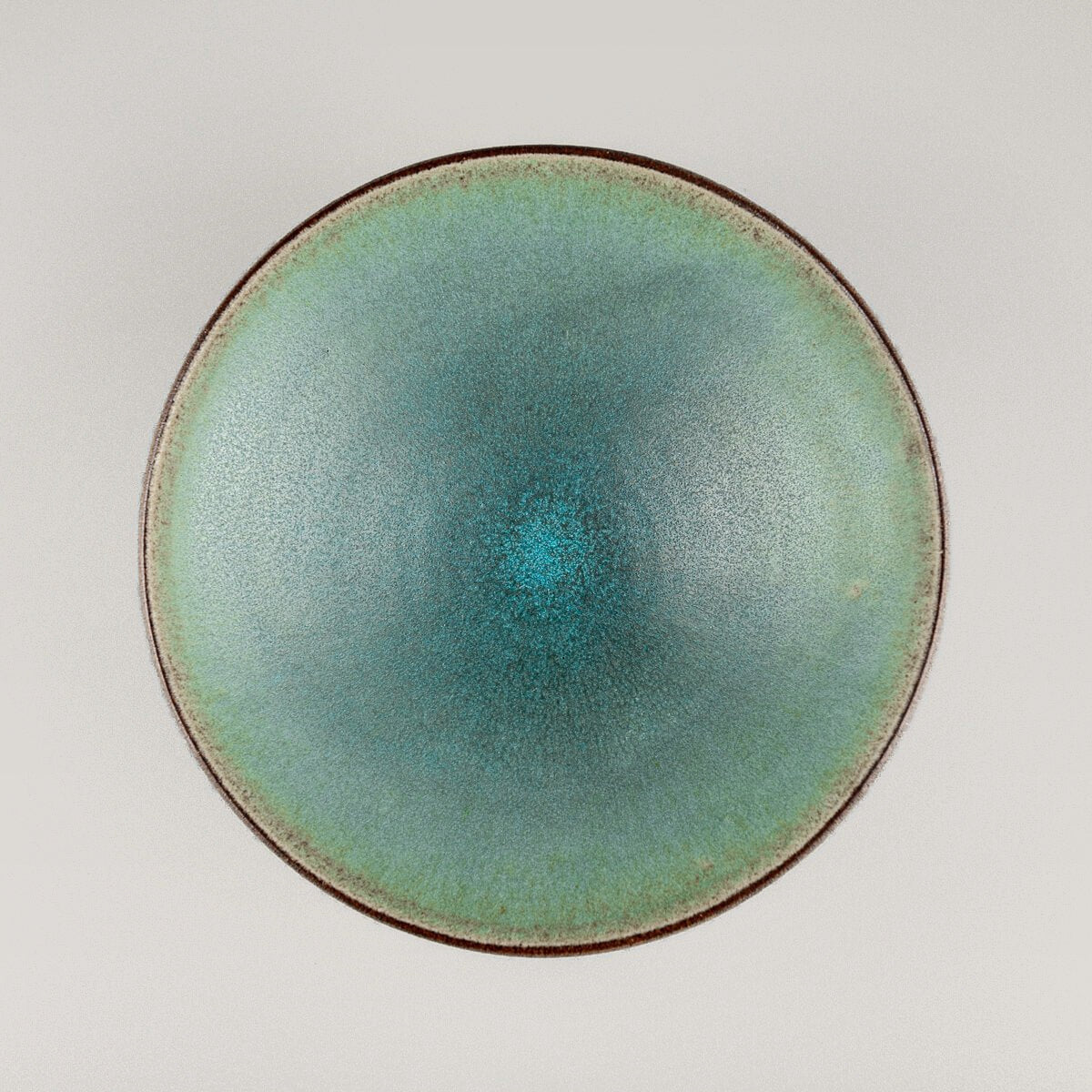 Elegant handmade ceramic plate with matte turquoise glaze for fine dining presentation.